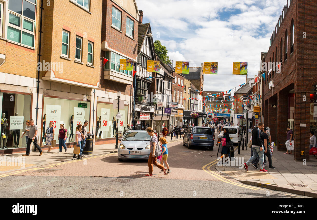 Les personnes qui traversent la route en une journée ensoleillée où la rue Thames se réunit, rue Clarence , la principale rue commerçante piétonne à Kingston Upon Thames, L Banque D'Images