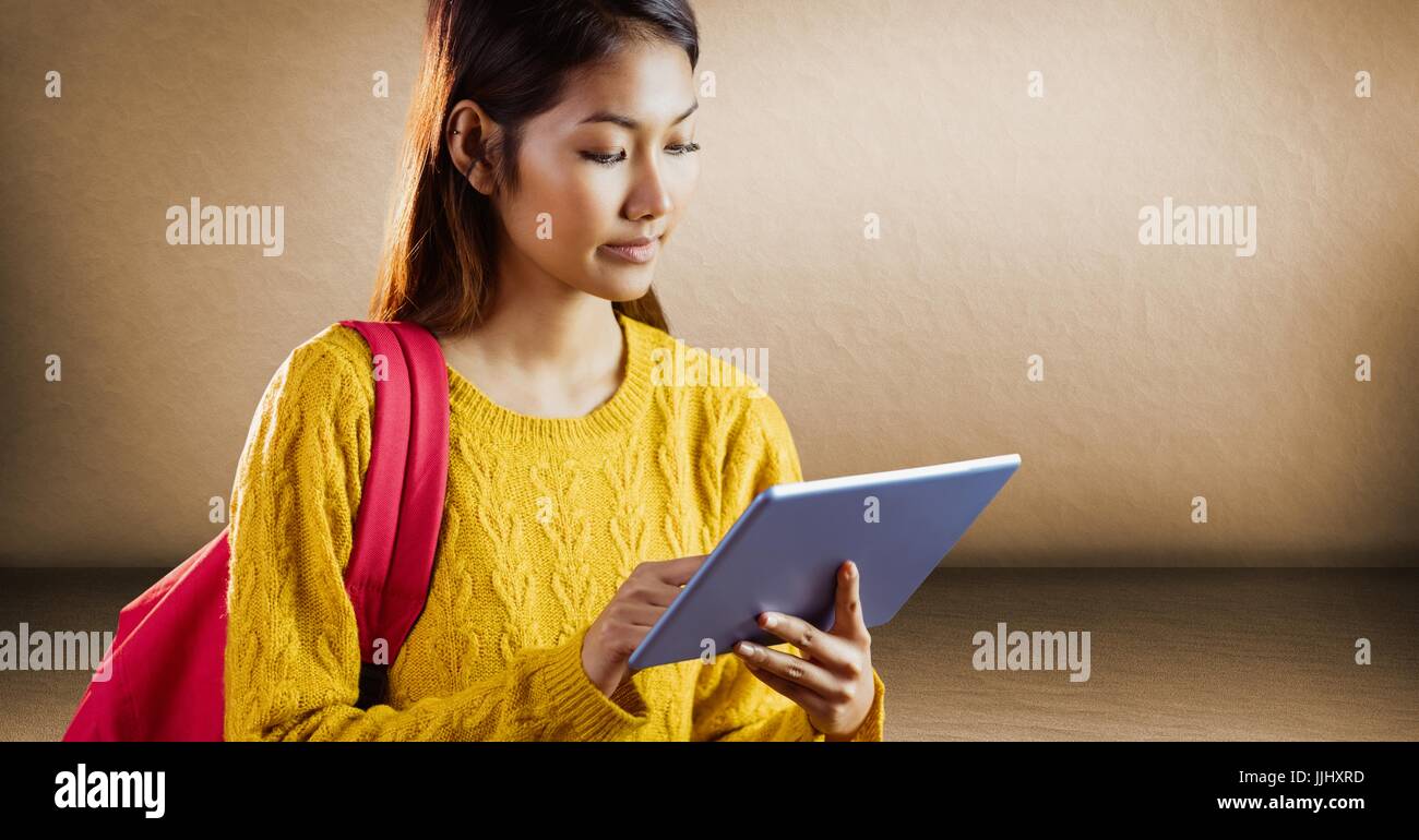 College student with tablet contre mur brun Banque D'Images