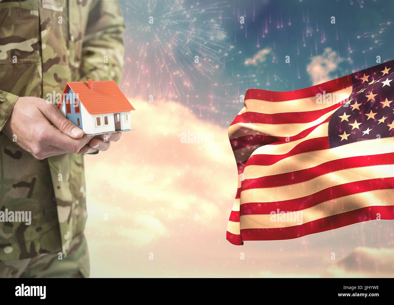 Soldat tenant une petite maison à proximité de le drapeau américain Banque D'Images