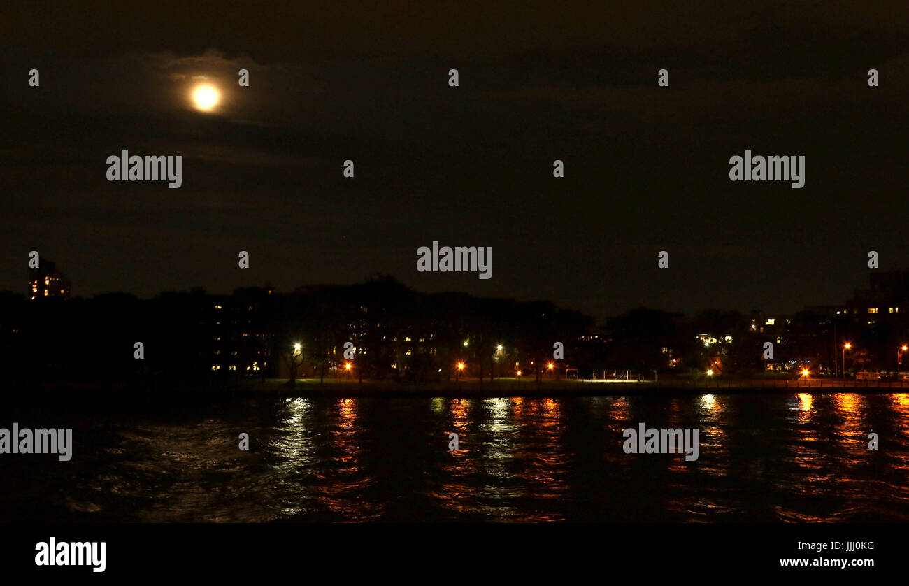Pleine lune sur la rivière de l'Est avec les lumières de la ville Banque D'Images