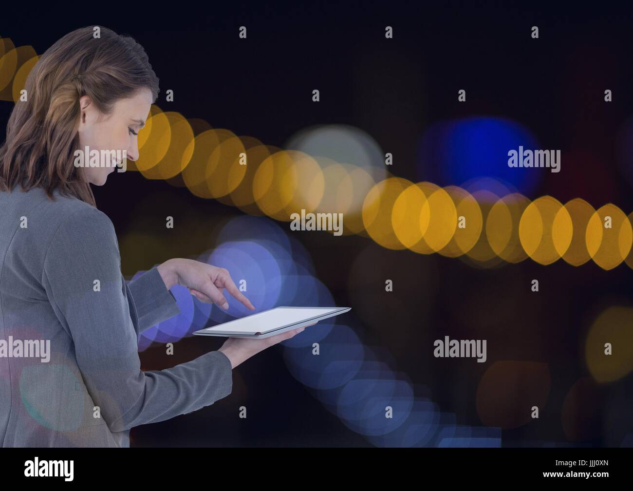 Smiling woman using a digital tablet de projecteurs Banque D'Images