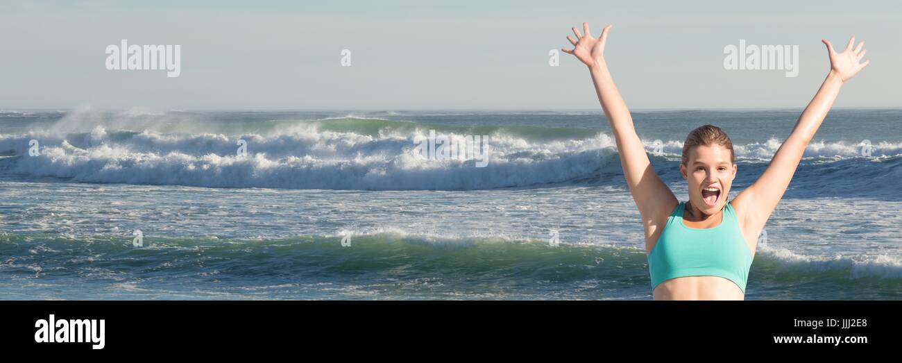 Femme en soutien-gorge de sport célèbre contre les vagues Banque D'Images