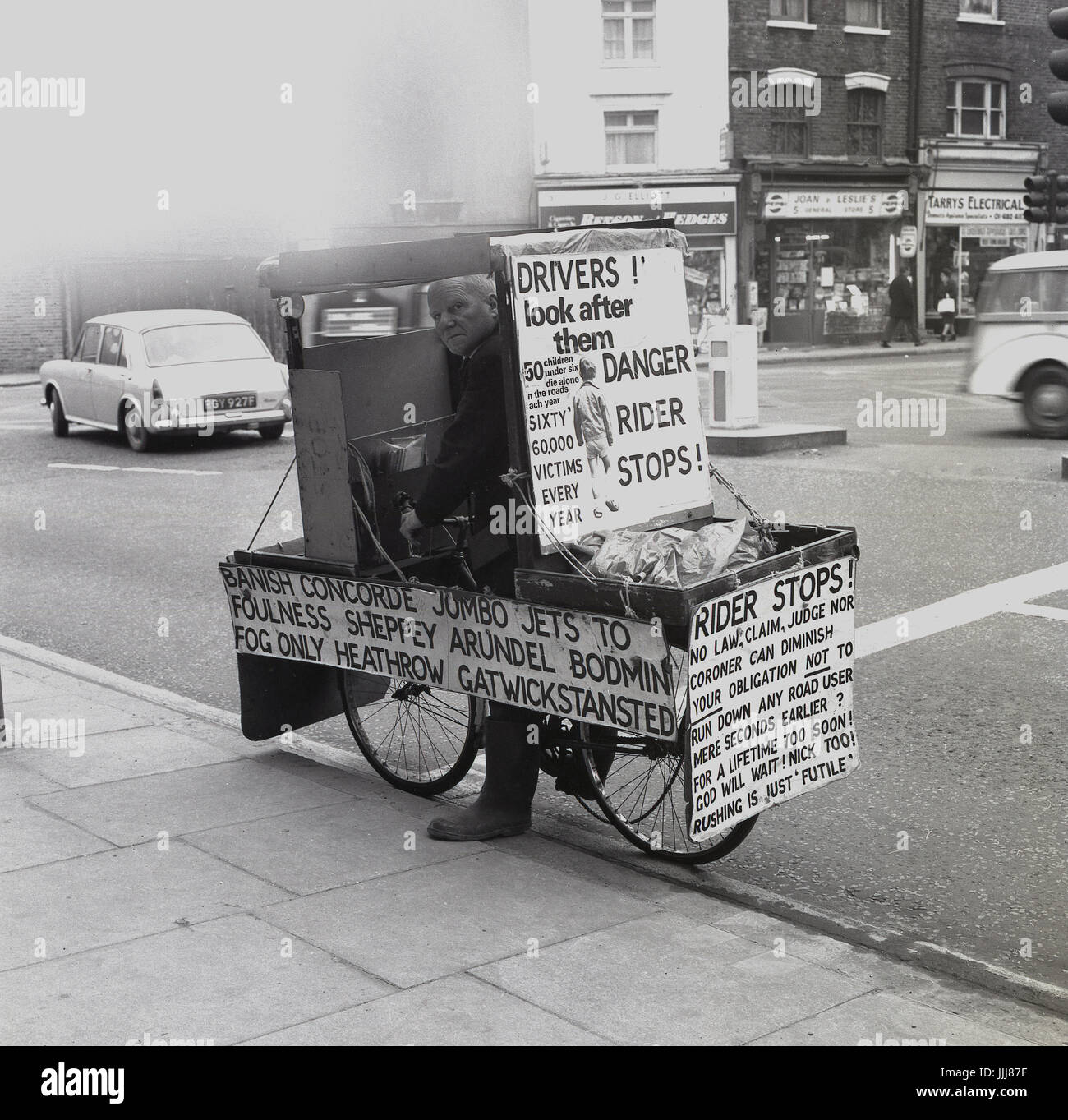 1971, Greenwich High Road, Londres, photo montre l'excentrique anglais et fervent candidat politique Le Lieutenant Com William (Bill) Boaks sur sa campagne 'BUS', un vélo couverts avec des pancartes et des panneaux sur la sécurité routière, une cause essentielle à ses croyances.. Banque D'Images