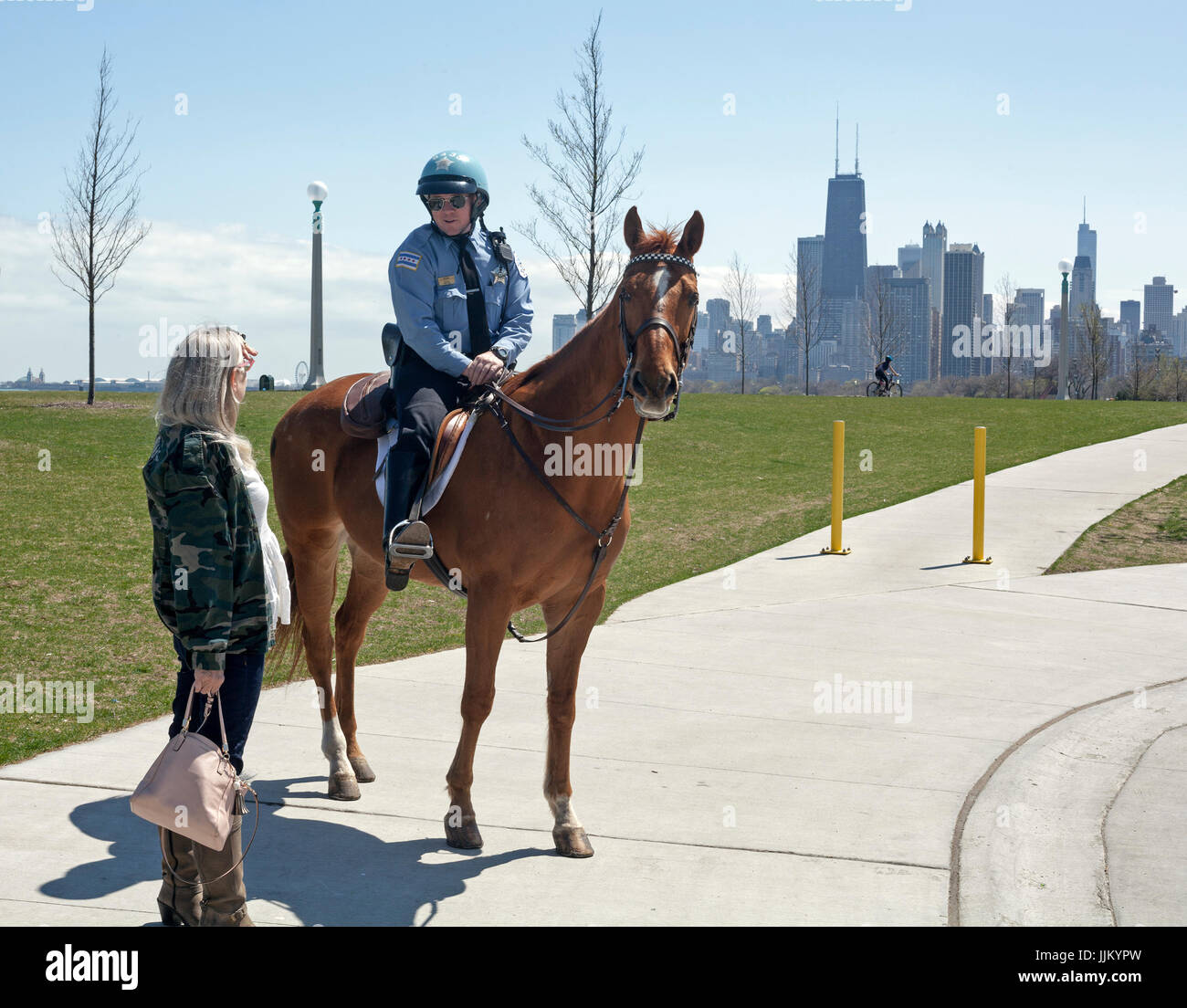 Un officier de la police montée contribue à un citoyen avec les directions dans un parc de Chicago. Banque D'Images