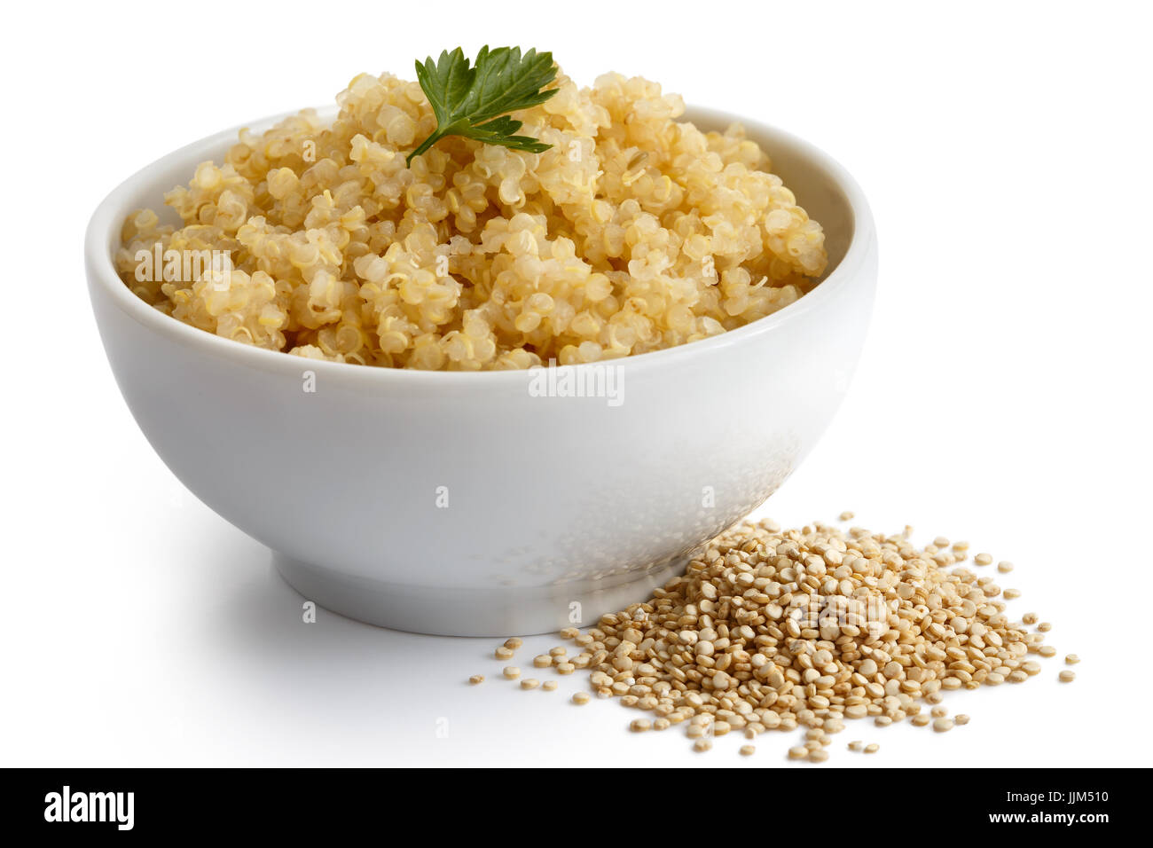 Le quinoa cuit dans un bol en céramique blanc isolé sur blanc avec persil vert. Le quinoa crus renversé. Banque D'Images