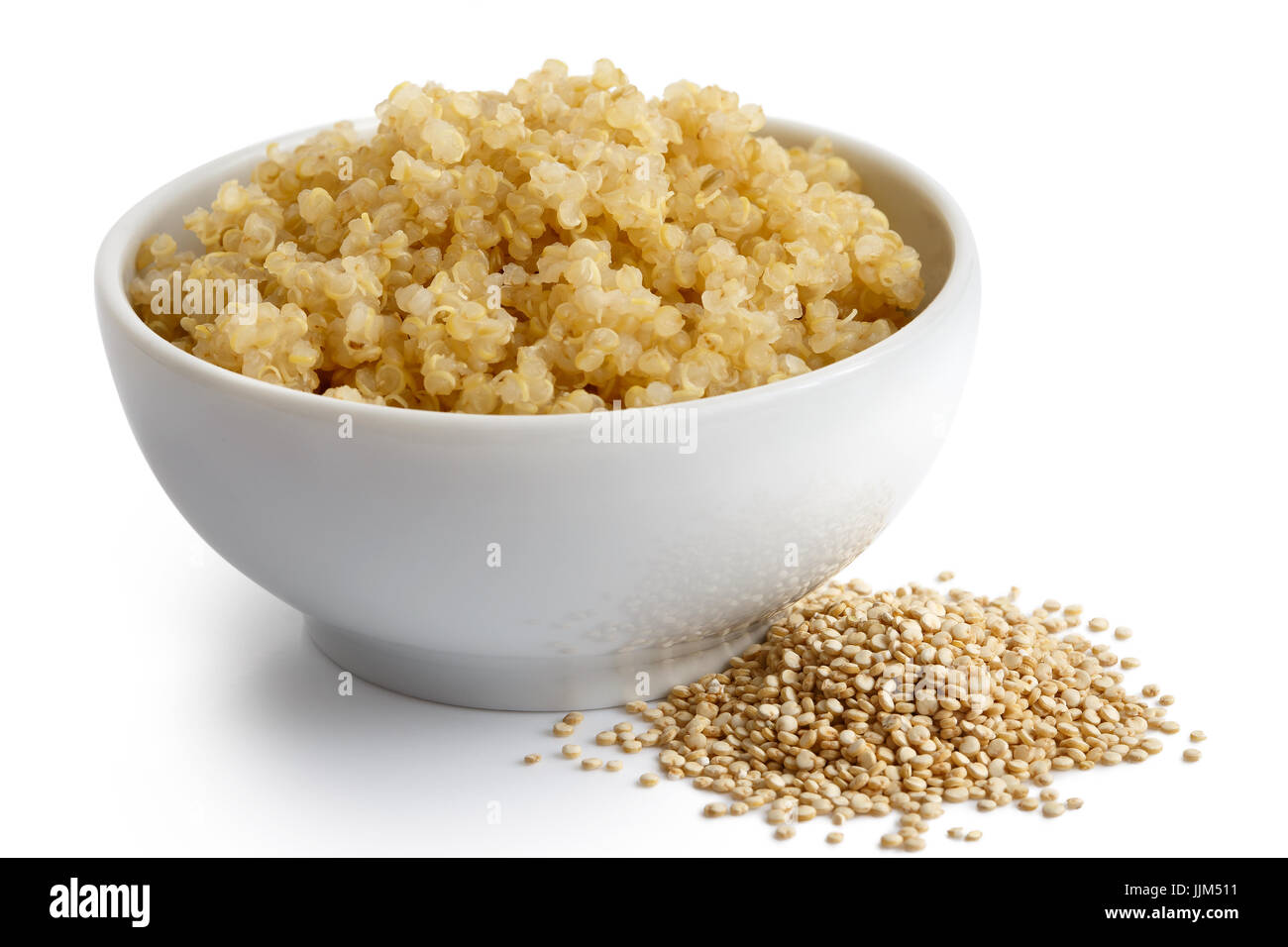 Le quinoa cuit dans un bol en céramique blanc isolé sur blanc. Le quinoa crus renversé. Banque D'Images