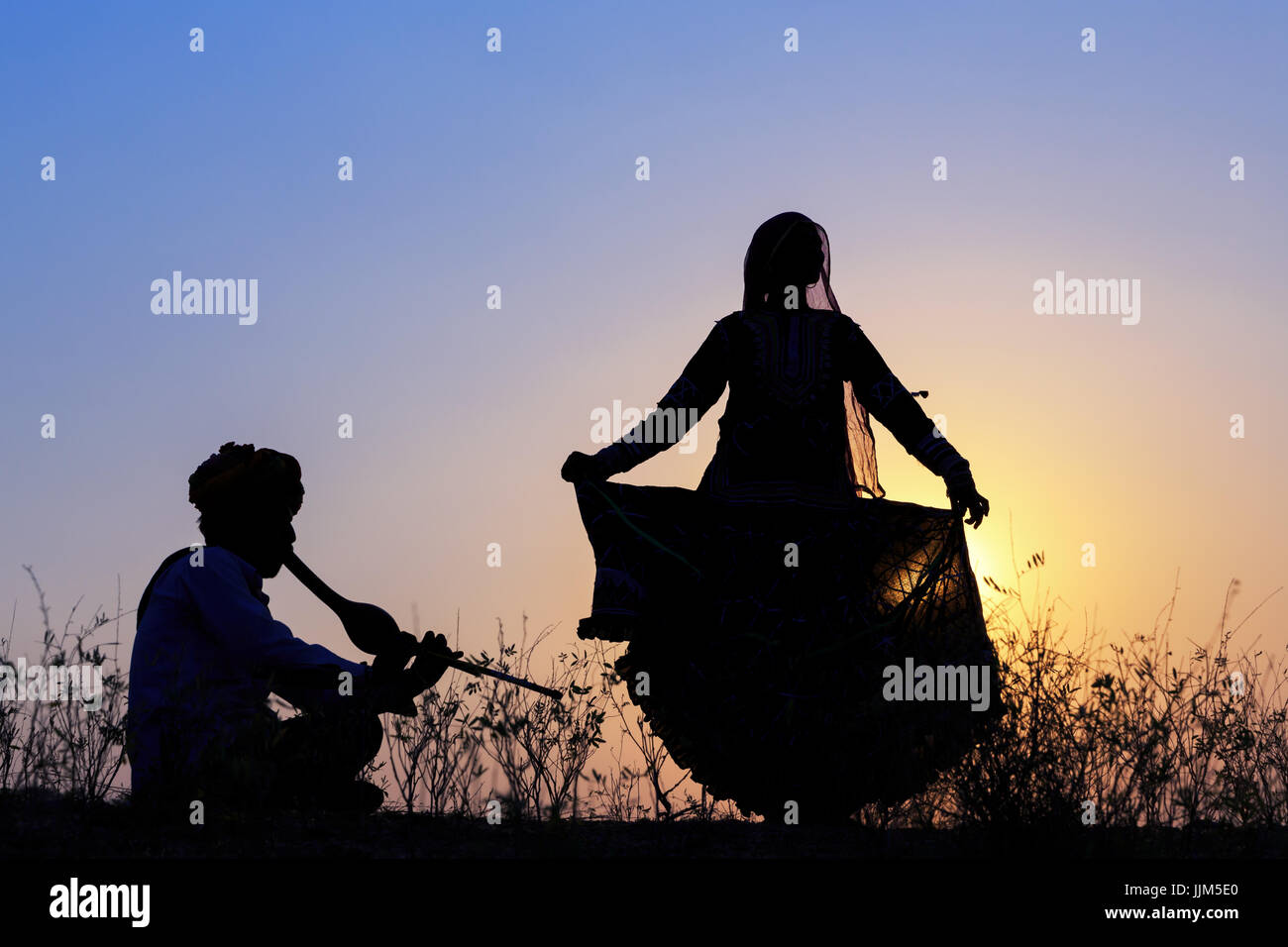 Silhouette d'une femme gitane danse une danse traditionnelle de la musique d'un musicien, Pushkar, Rajasthan, India Banque D'Images