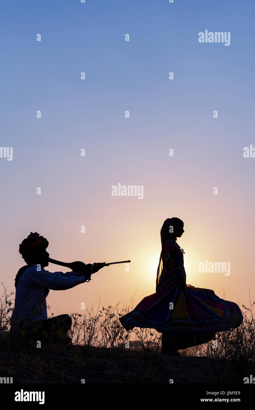 Une gitane danser devant le soleil couchant, Pushkar Camel Fair, Pushkar, Rajasthan, India Banque D'Images