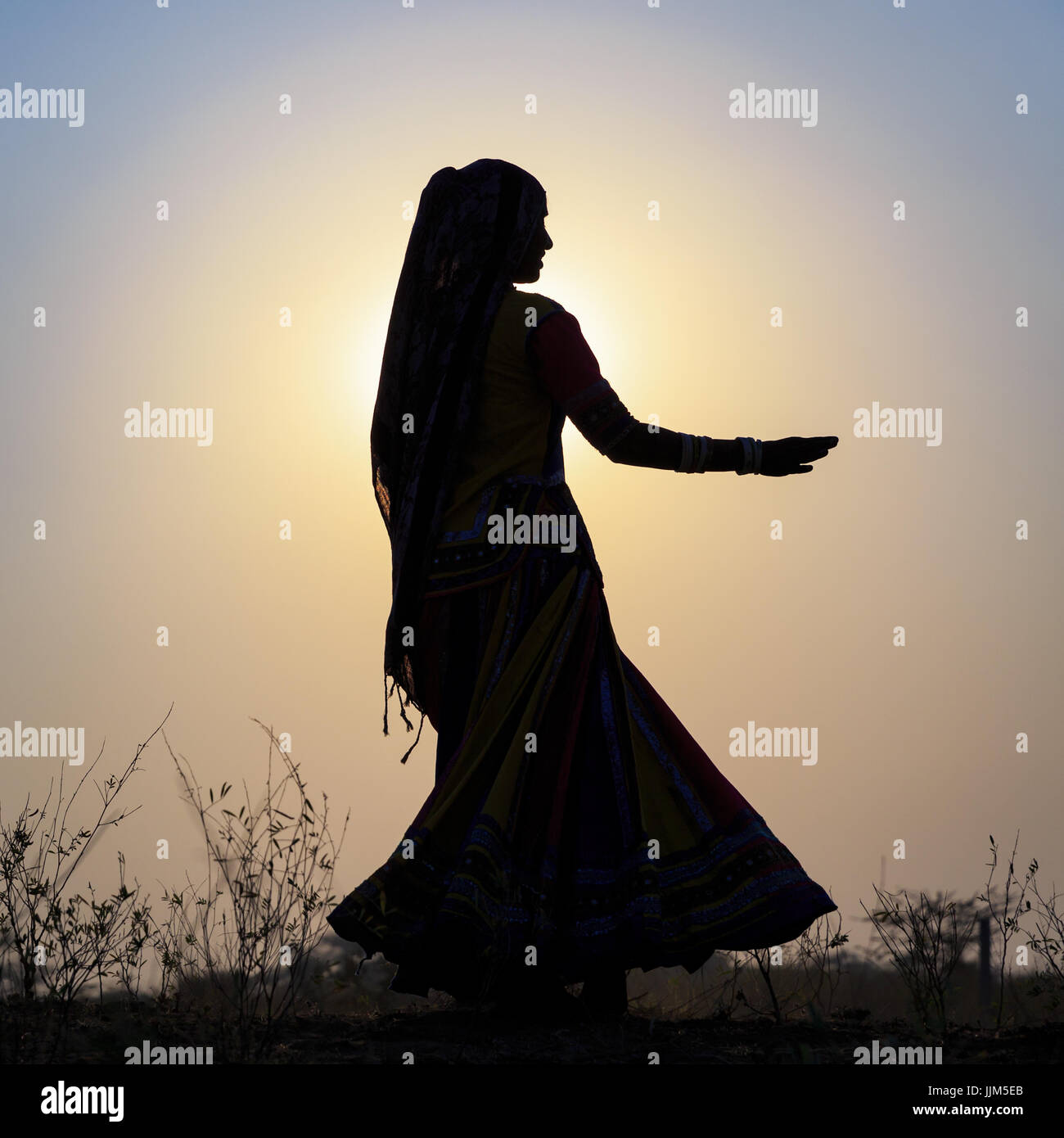 Une gitane danser devant le soleil couchant, Pushkar Camel Fair, Pushkar, Rajasthan, India Banque D'Images