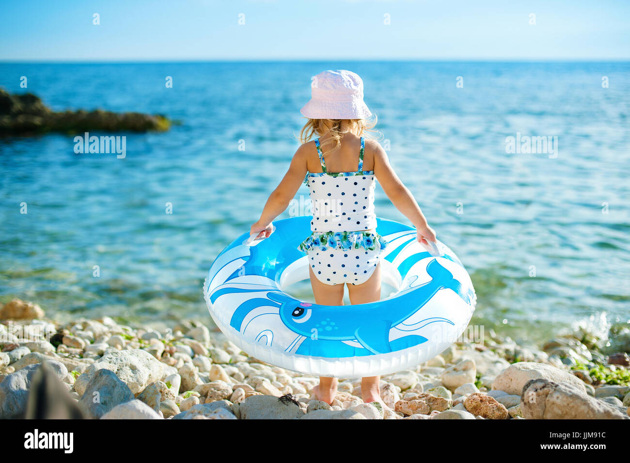 Une Petite Fille Avec Une Grande Bouee Se Dresse Sur La Rive Entrer Dans L Eau Concept De Locations L Enfance Photo Stock Alamy