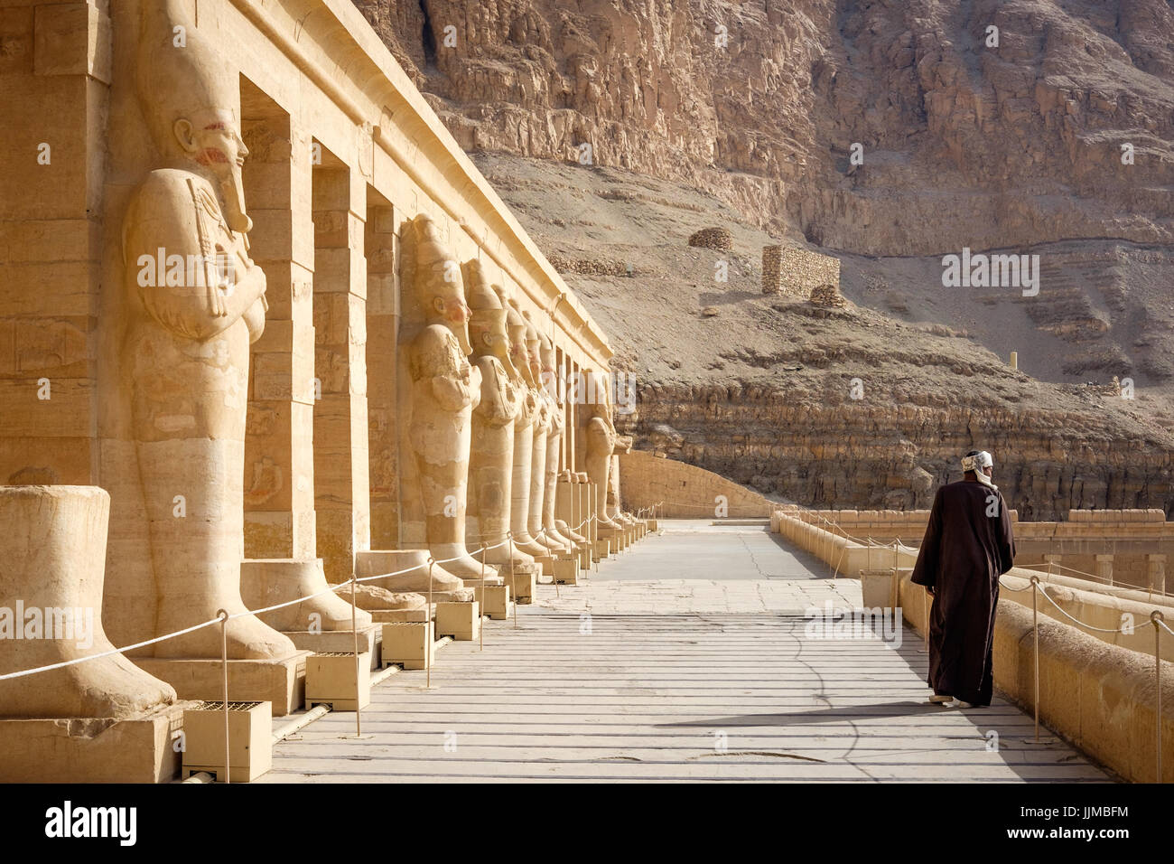Un garde marche le long du porche du temple mortuaire d'Hatshepsout à Deir el-Bahri, en Égypte, tôt le matin. Banque D'Images