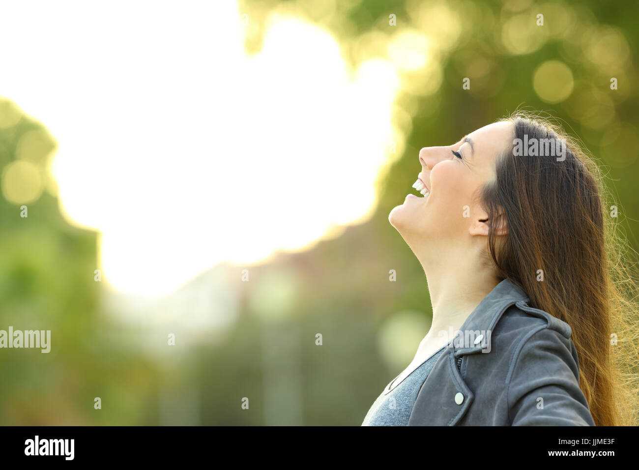 Vue latérale d'une mode portrait femme respirer l'air frais extérieur avec un fond vert Banque D'Images