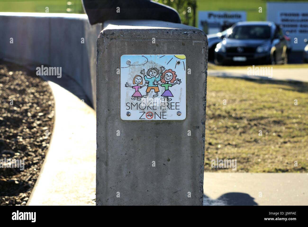 Concept éditorial d'illustration. Fumée signe free zone' sur le mur avec le bas du corps de l'enfant assis sur le mur en vue. Coffs Harbour, NSW Australie. Banque D'Images