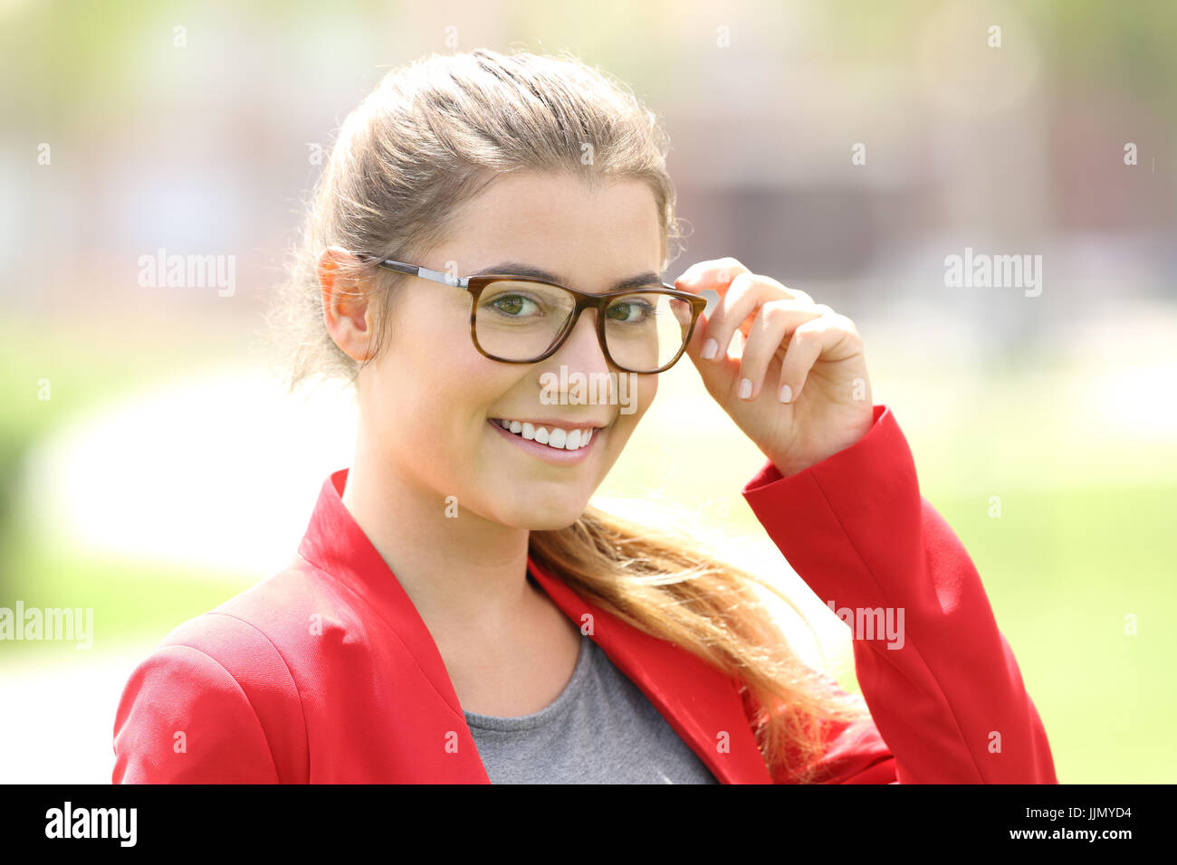 Fashion girl posing looking at you portant des lunettes à l'extérieur dans un parc Banque D'Images