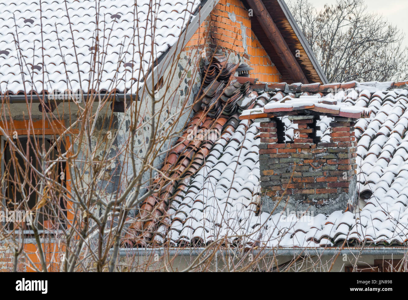 Grande et ancienne cheminée en brique avec de la neige, ancien pavillon avec grande cheminée Banque D'Images