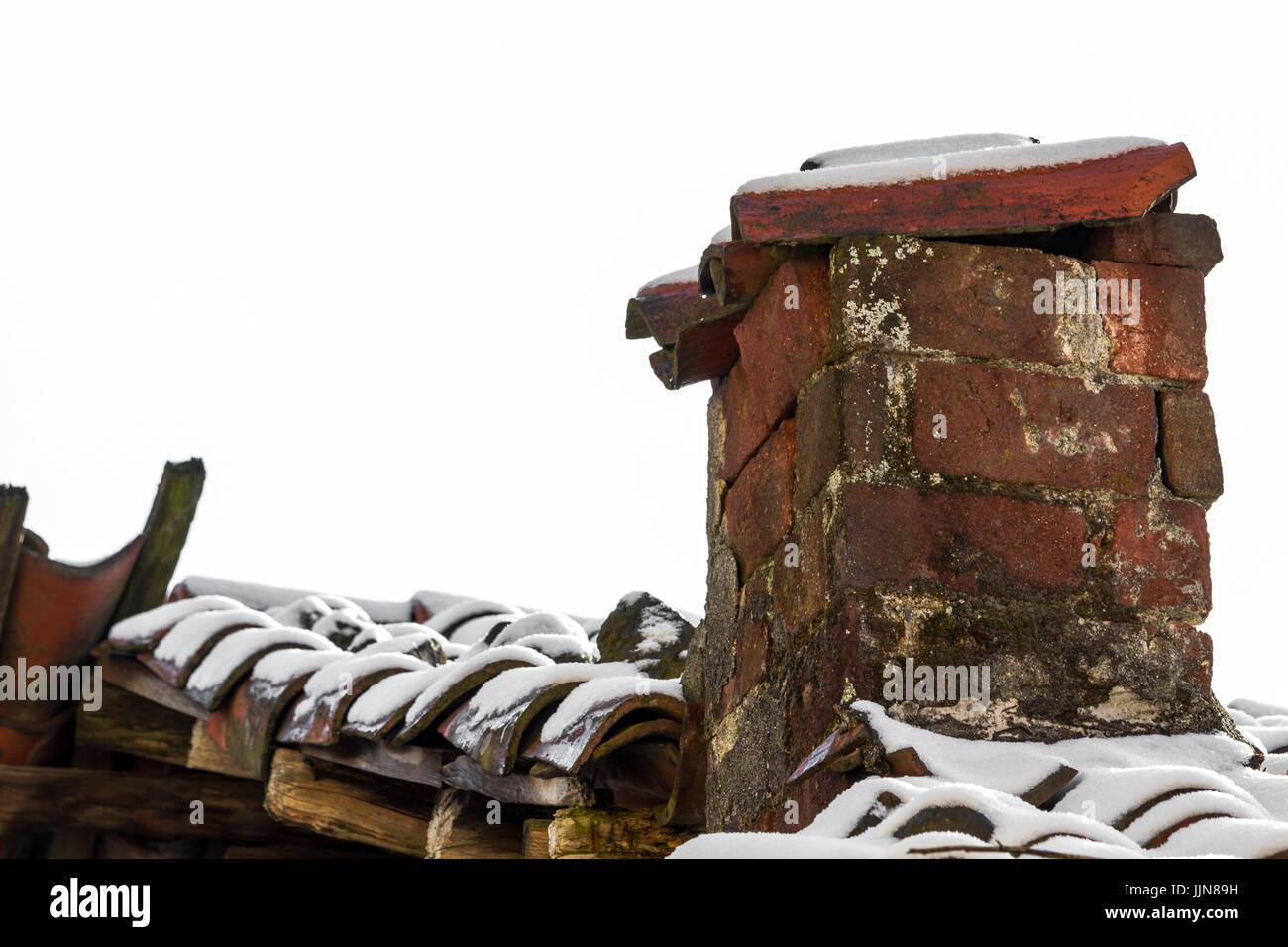 Ancienne cheminée en brique abandonnés dans la neige avec fond blanc Banque D'Images