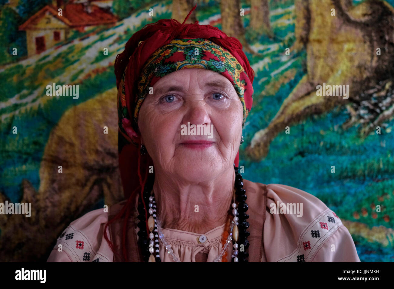 Une femme russe âgée portant une robe sarafan traditionnelle dans le village de Sibirjachiha dont ses membres préservent les coutumes et traditions des vieux croyants avec des fondations datant de centaines d'années situées dans le district de Soloneshenskiy du Krai de l'Altaï en Sibérie occidentale, Russie. Les vieux croyants ou vieux ritualistes sont des chrétiens orthodoxes orientaux qui maintiennent les pratiques liturgiques et rituelles de l’Église russe telles qu’elles étaient avant les réformes du patriarche Nikon de Moscou entre 1652 et 1666. Banque D'Images
