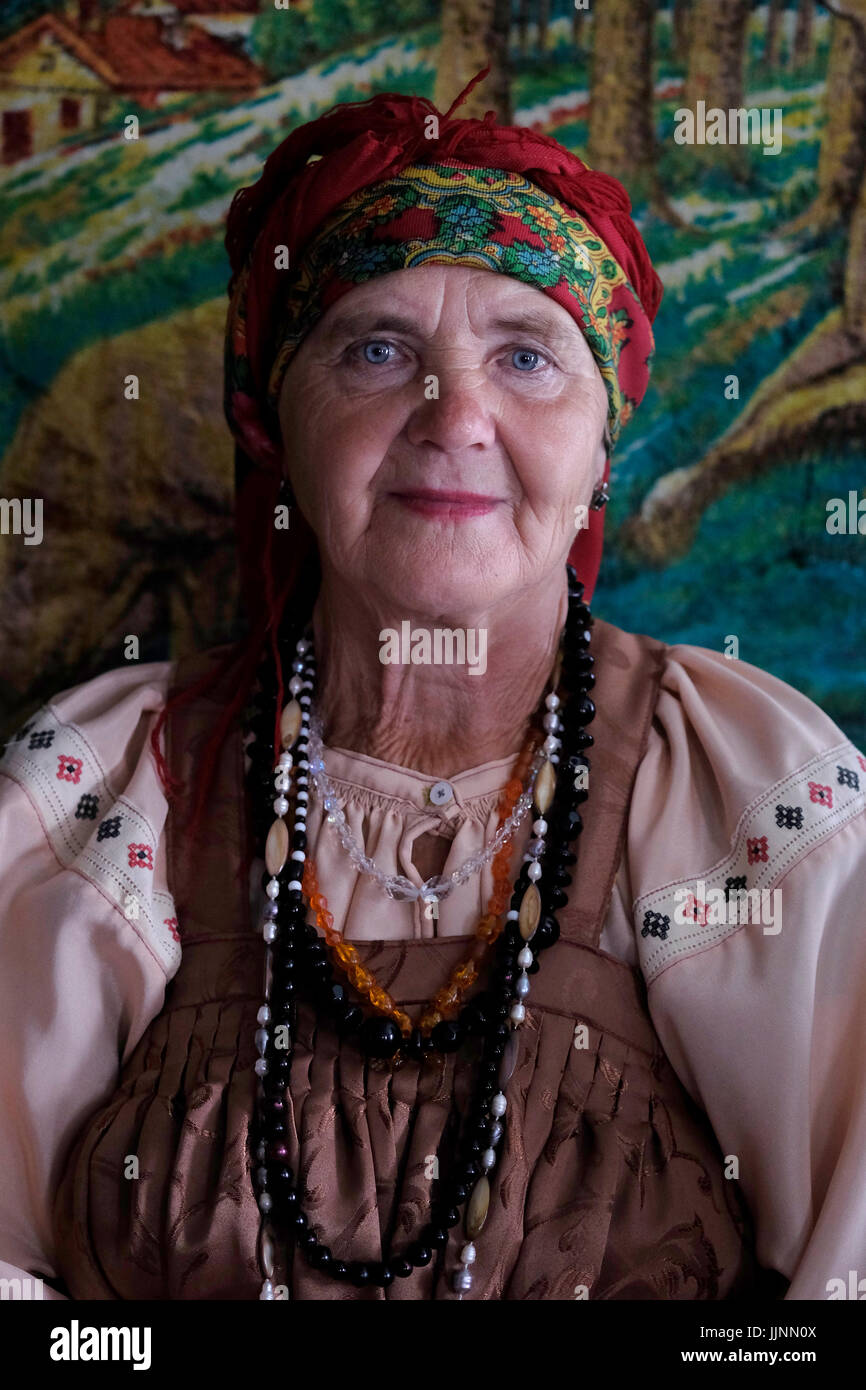 Une femme russe âgée portant une robe sarafan traditionnelle dans le village de Sibirjachiha dont ses membres préservent les coutumes et traditions des vieux croyants avec des fondations datant de centaines d'années situées dans le district de Soloneshenskiy du Krai de l'Altaï en Sibérie occidentale, Russie. Les vieux croyants ou vieux ritualistes sont des chrétiens orthodoxes orientaux qui maintiennent les pratiques liturgiques et rituelles de l’Église russe telles qu’elles étaient avant les réformes du patriarche Nikon de Moscou entre 1652 et 1666. Banque D'Images