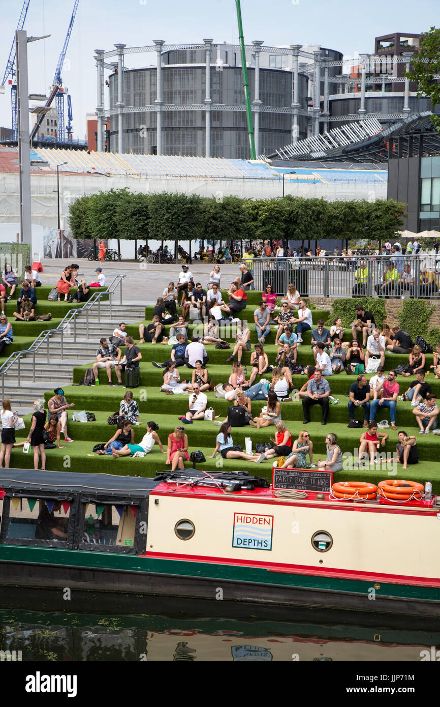 Les jeunes de London à prendre le soleil dans un coin salon extérieur Grenier Square, Kings Cross, et à côté du Grand Union canal. L'Université des Arts i. Banque D'Images