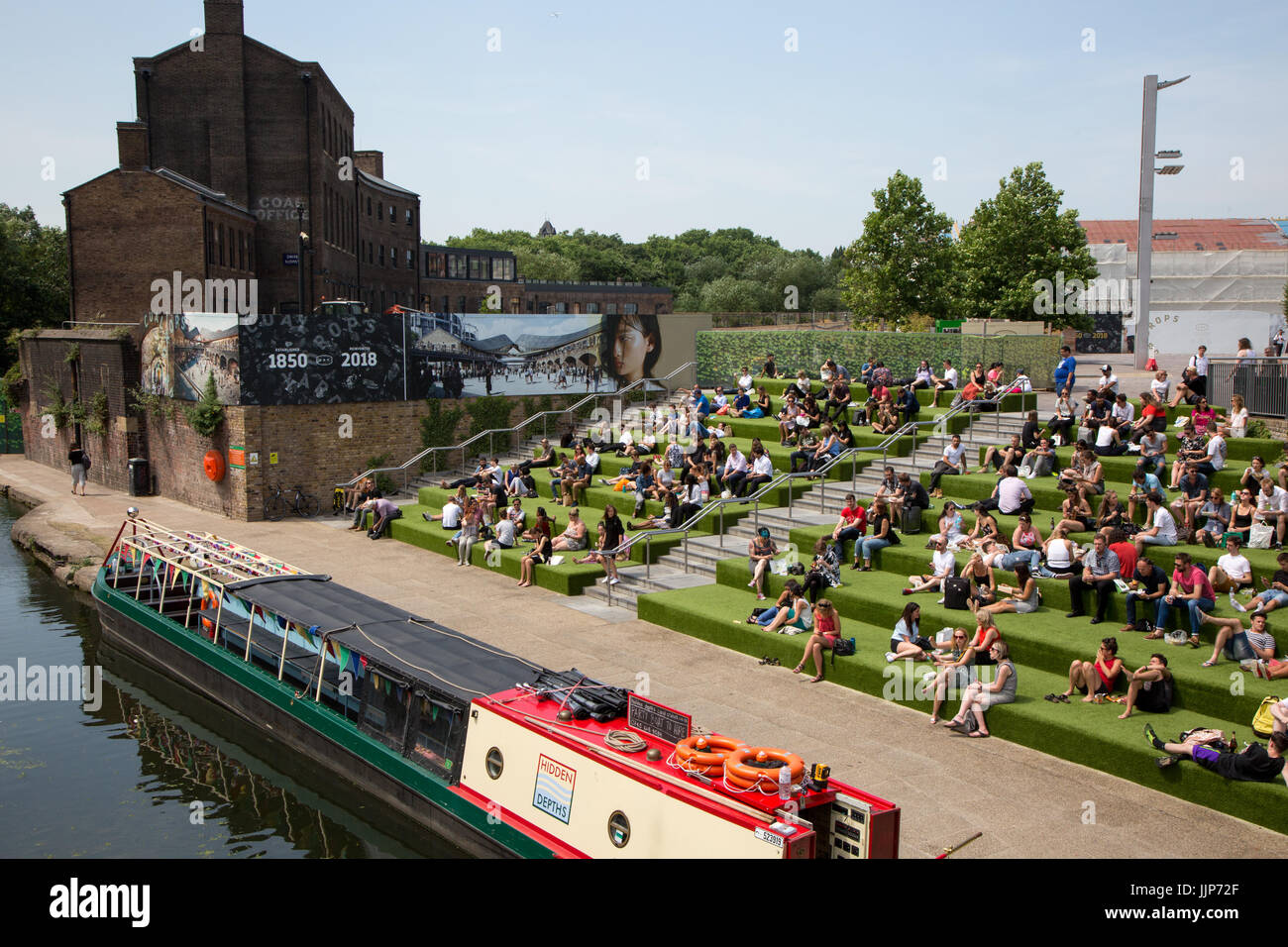 Les jeunes de London à prendre le soleil dans un coin salon extérieur Grenier Square, Kings Cross, et à côté du Grand Union canal. L'Université des Arts i. Banque D'Images