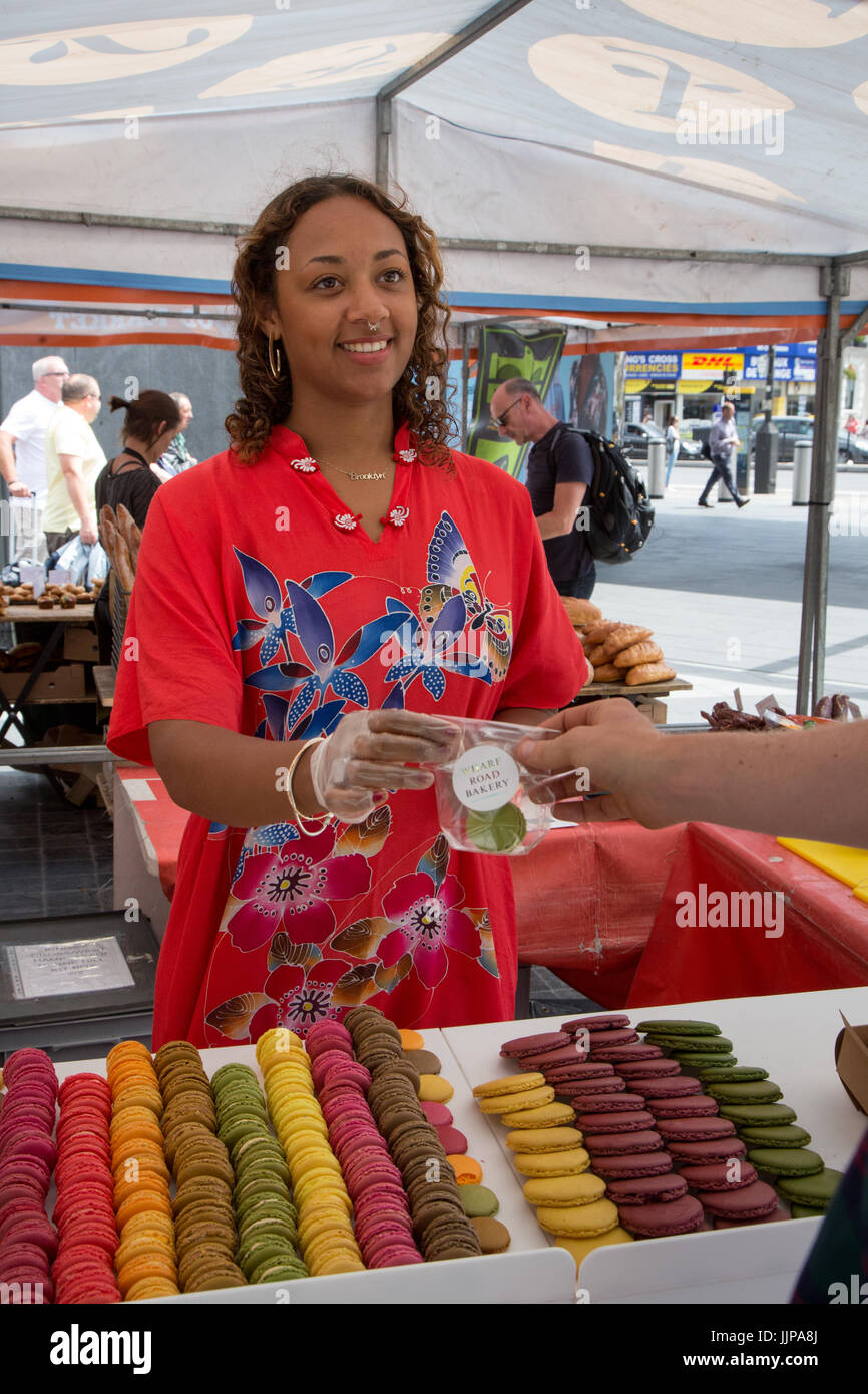 Le vrai marché alimentaire à l'extérieur de la gare de King's Cross, Londres. Ce commerçant vend des macarons Banque D'Images