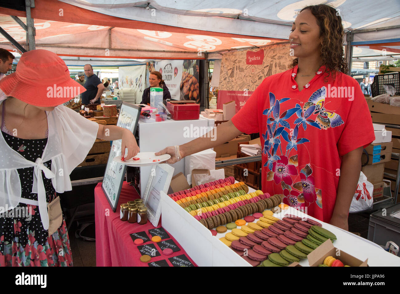 Le vrai marché alimentaire à l'extérieur de la gare de King's Cross, Londres. Ce commerçant vend des macarons Banque D'Images