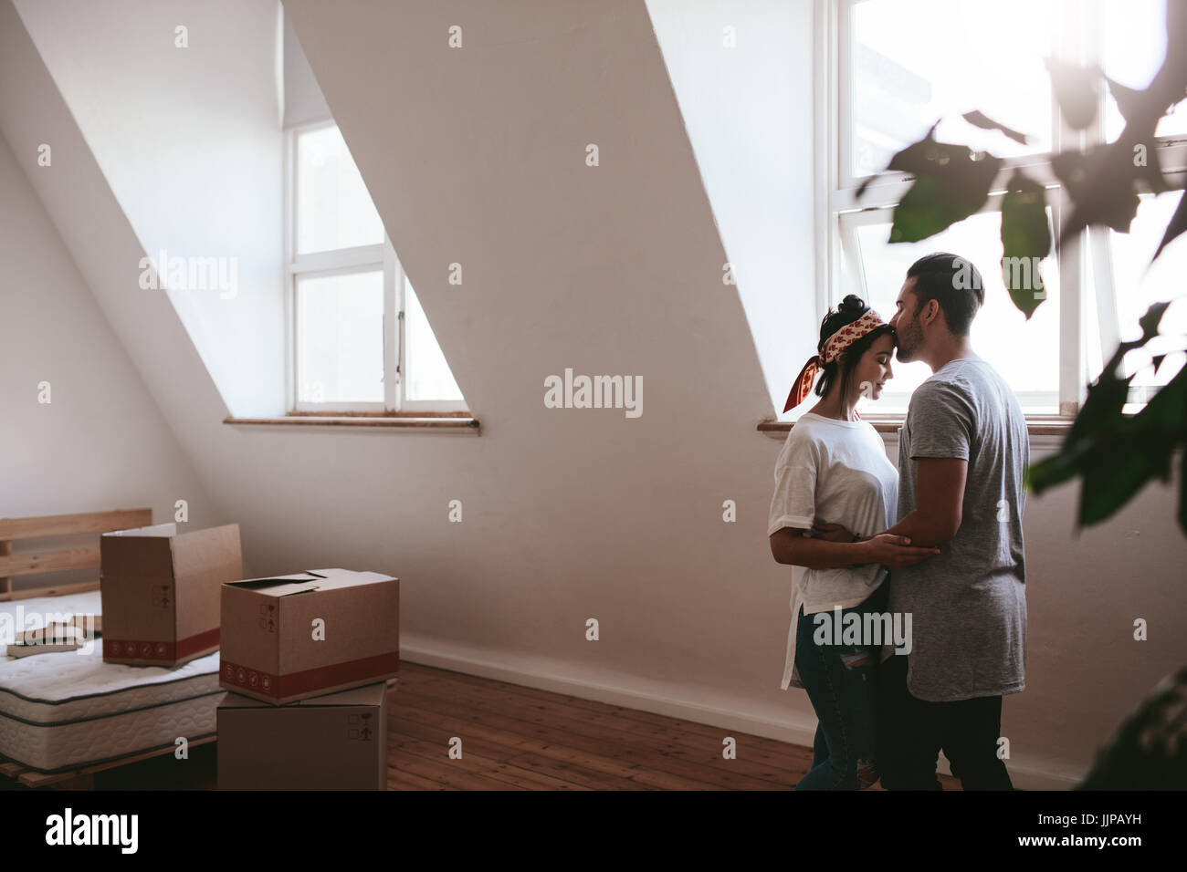 Tourné à l'intérieur de l'amour jeune couple déménagement dans leur nouvelle maison. L'homme et la femme en amour avec commandes de boîtes de carton dans la chambre. Banque D'Images