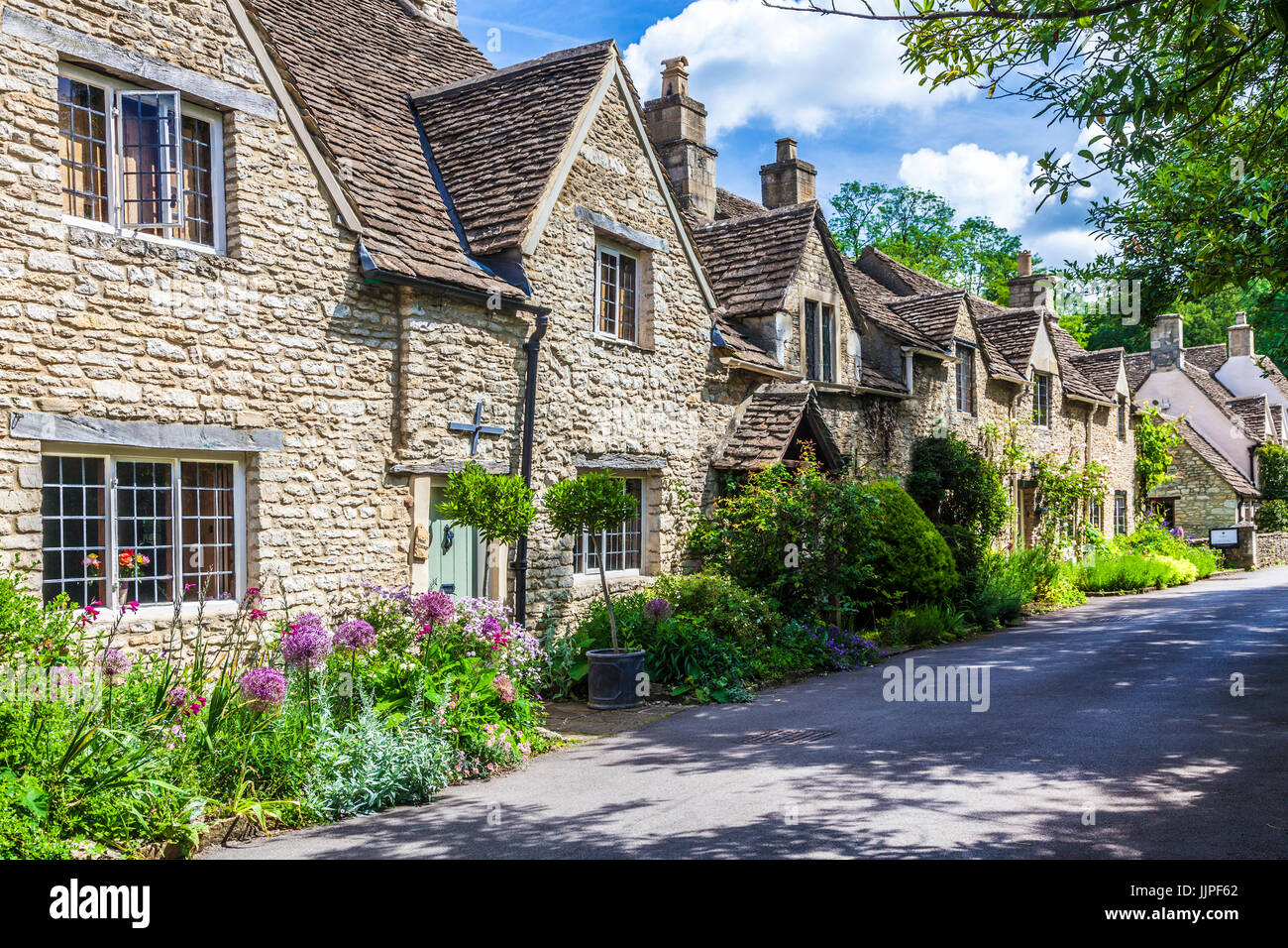 Une ruelle de jolis cottages en pierre mitoyenne dans le village de Castle Combe Cotswolds dans le Wiltshire. Banque D'Images