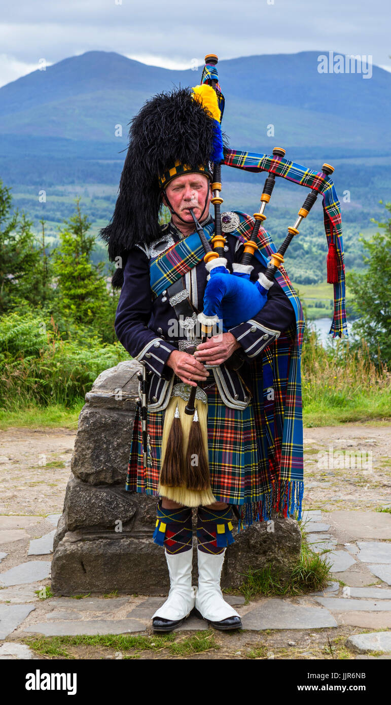 Piper écossais traditionnel jouant de la cornemuse au Glen Garry viewpoint, Highlands, Scotland, UK Banque D'Images