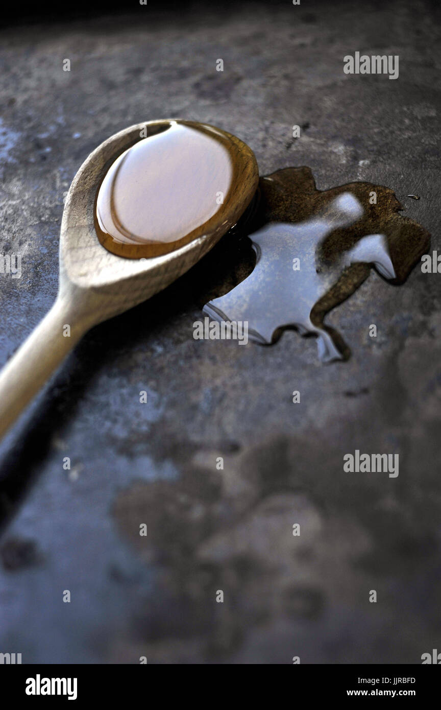 Cuillère en bois plein de miel liquide Banque D'Images