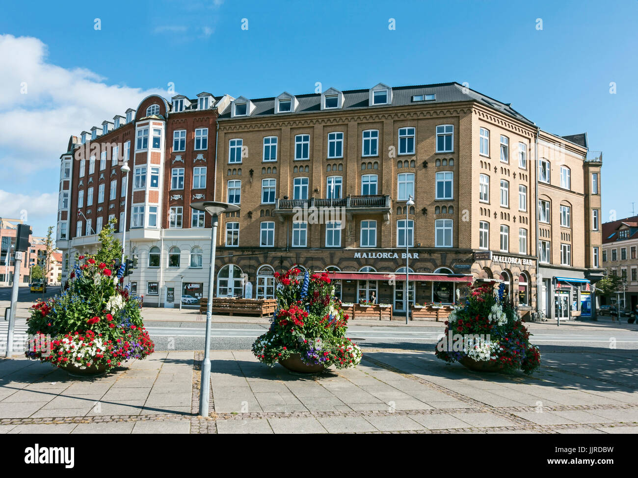 Fleurs municipales à John F. Kennedy à Aalborg Danemark Europe Jutland avec maison bloc et Mallorca bar derrière Banque D'Images