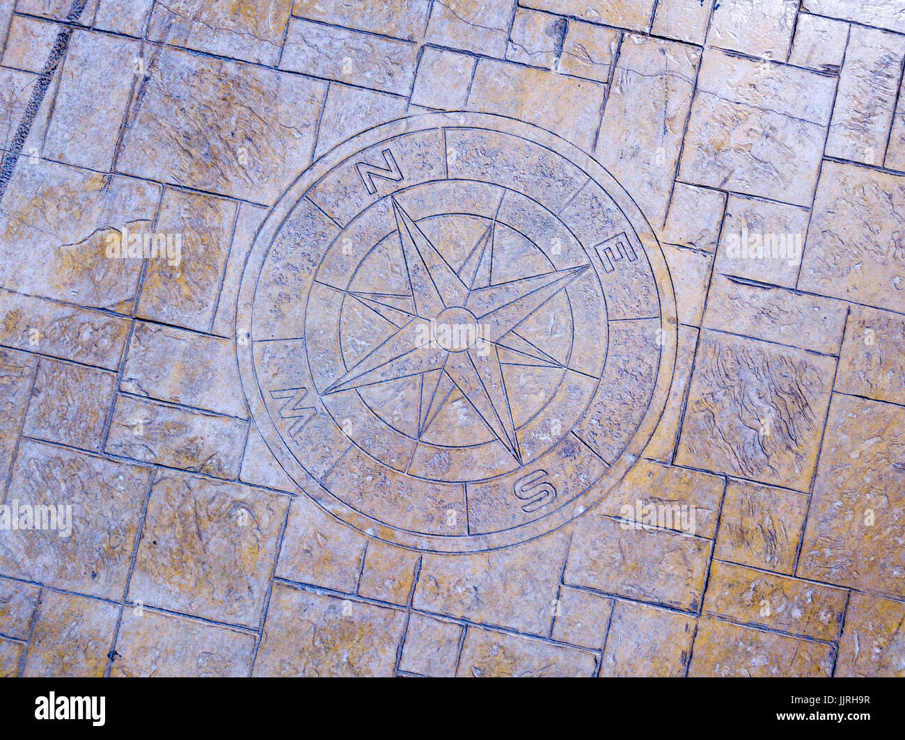 Rose des vents et points cardinaux incrusté dans un trottoir d'un pilier Banque D'Images