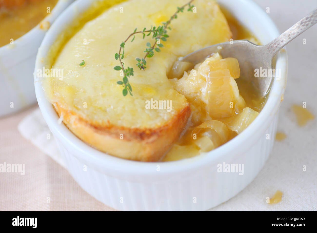 Un petit bol de soupe à l'oignon au fromage fondu de pain grillé et de branches de thym sur le dessus Banque D'Images