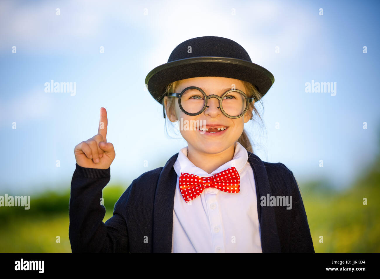 Funny little girl à lunettes, noeud papillon et chapeau melon. Banque D'Images