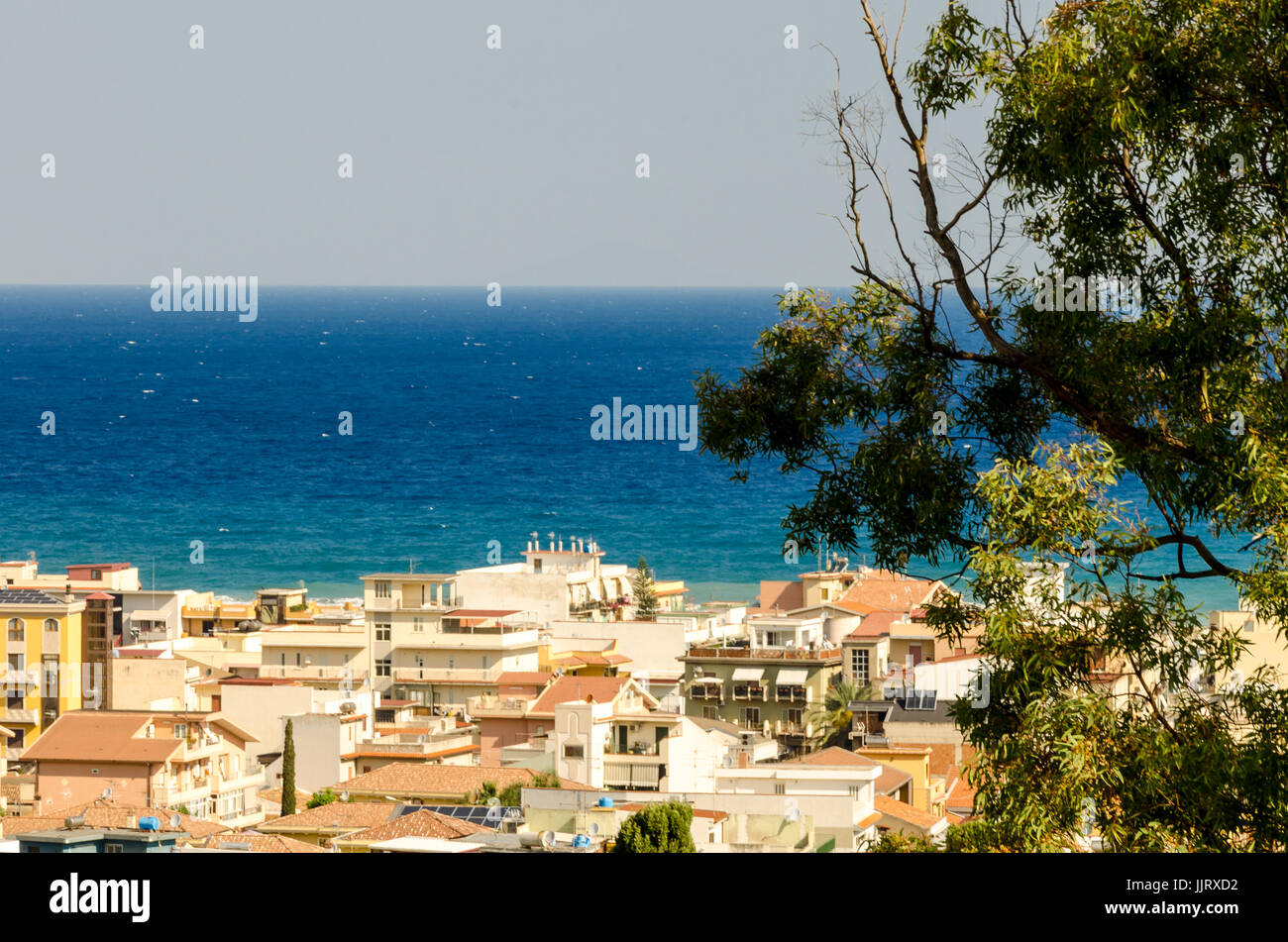 Dans le bleu de l'intensité de la mer Méditerranée, donnent sur les maisons d'un pays sicilien Banque D'Images