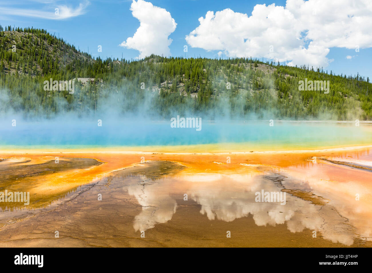 Les nuages reflètent dans les couleurs arc-en-ciel vif du Grand Prismatic Spring dans le Parc National de Yellowstone, Wyoming Banque D'Images