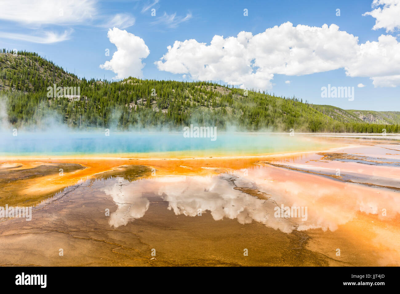 Les nuages reflètent dans les couleurs arc-en-ciel vif du Grand Prismatic Spring dans le Parc National de Yellowstone, Wyoming Banque D'Images