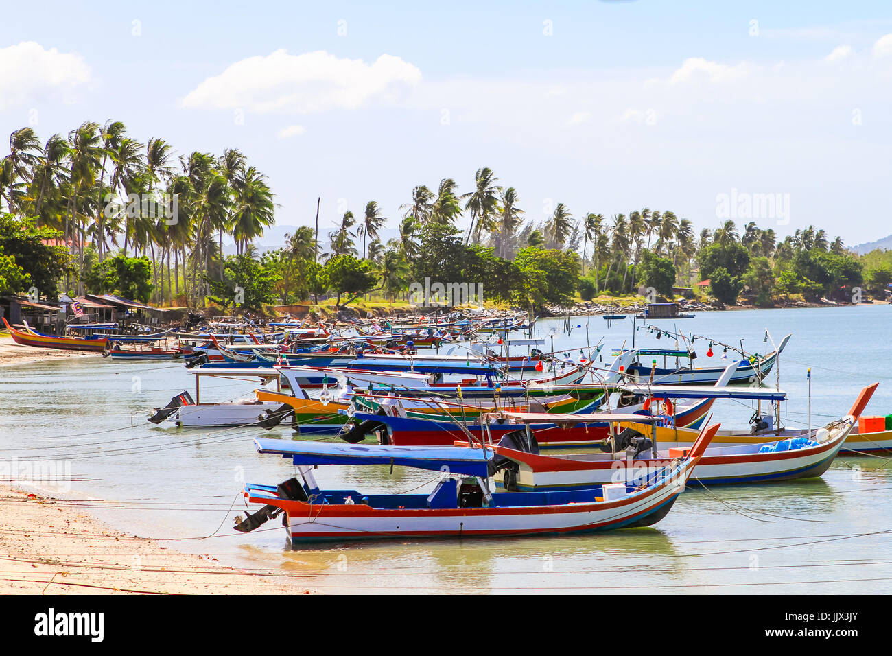 Les bateaux de pêche traditionnels asiatiques ancrées à proximité des maisons de pêcheur dans la baie. Langkawi, Malaisie. Banque D'Images
