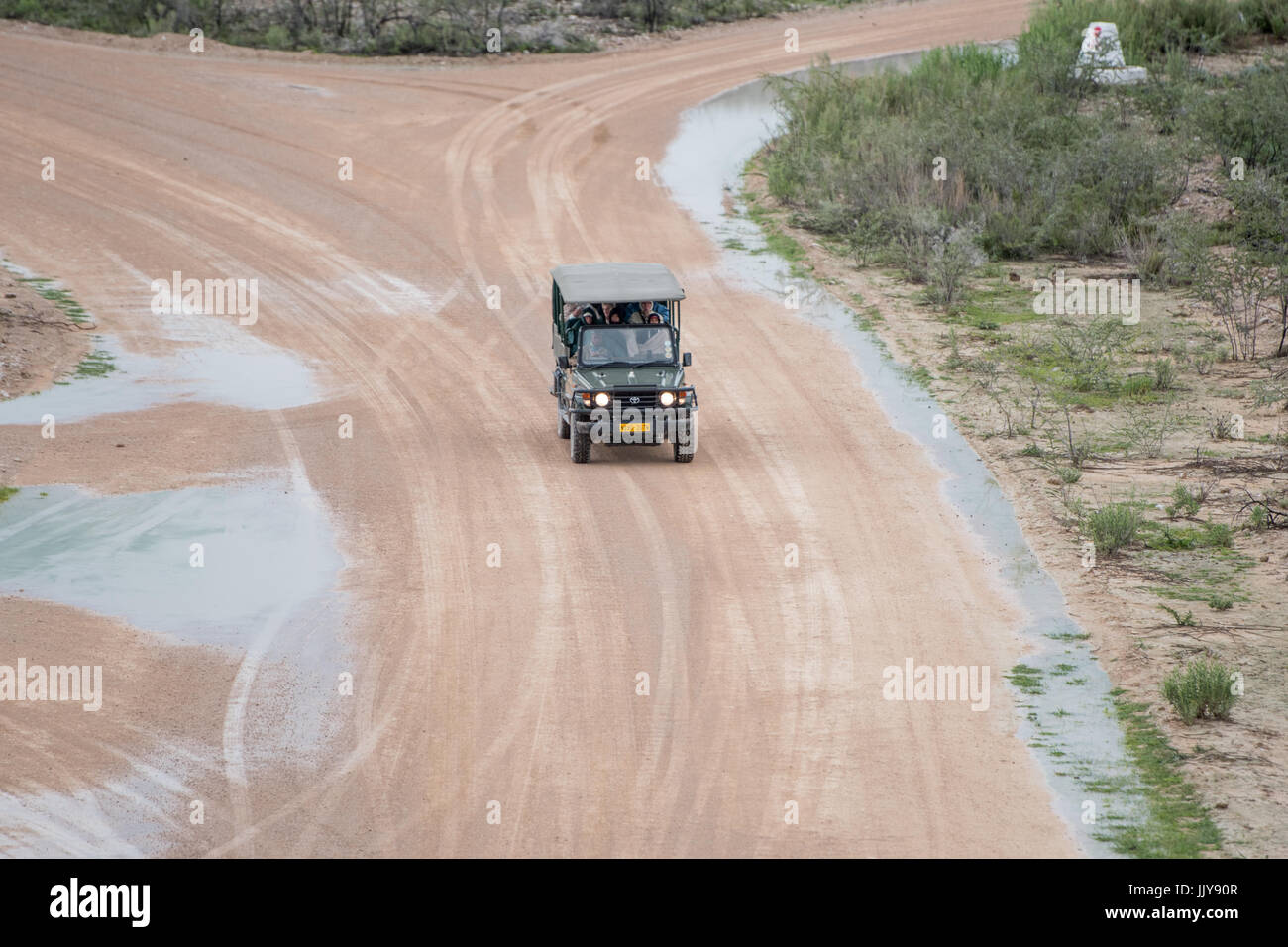 Un véhicule sport rempli de passagers sur les chemins de terre à travers Etosha National Park, situé en Namibie, l'Afrique. Banque D'Images