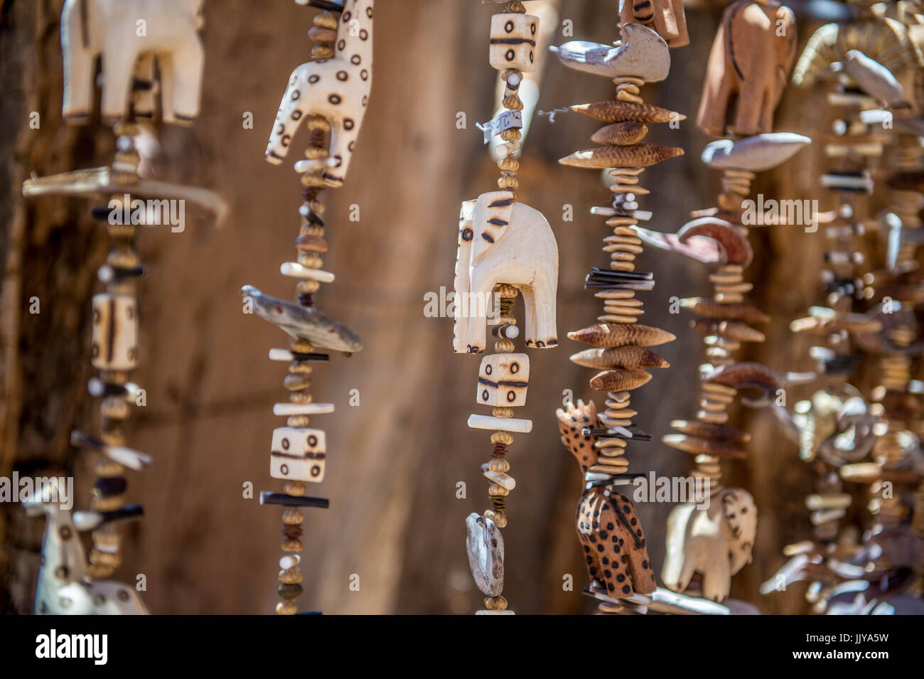 Sculpté à la main en bois, figurines d'animaux et des perles sont suspendus dans une hutte au Musée Vivant Damara, situé à Twyfelfontein, la Namibie, l'Afrique. Banque D'Images