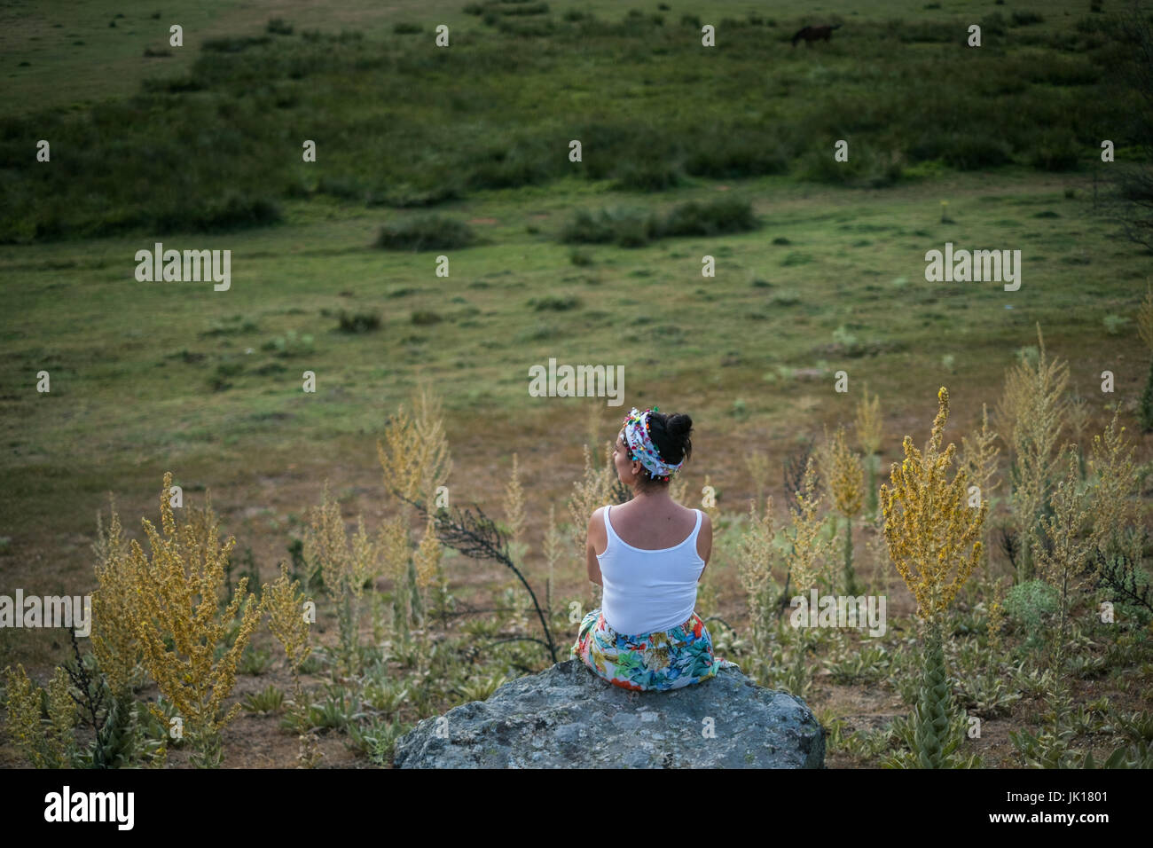 Femme assise sur le rocher Banque D'Images