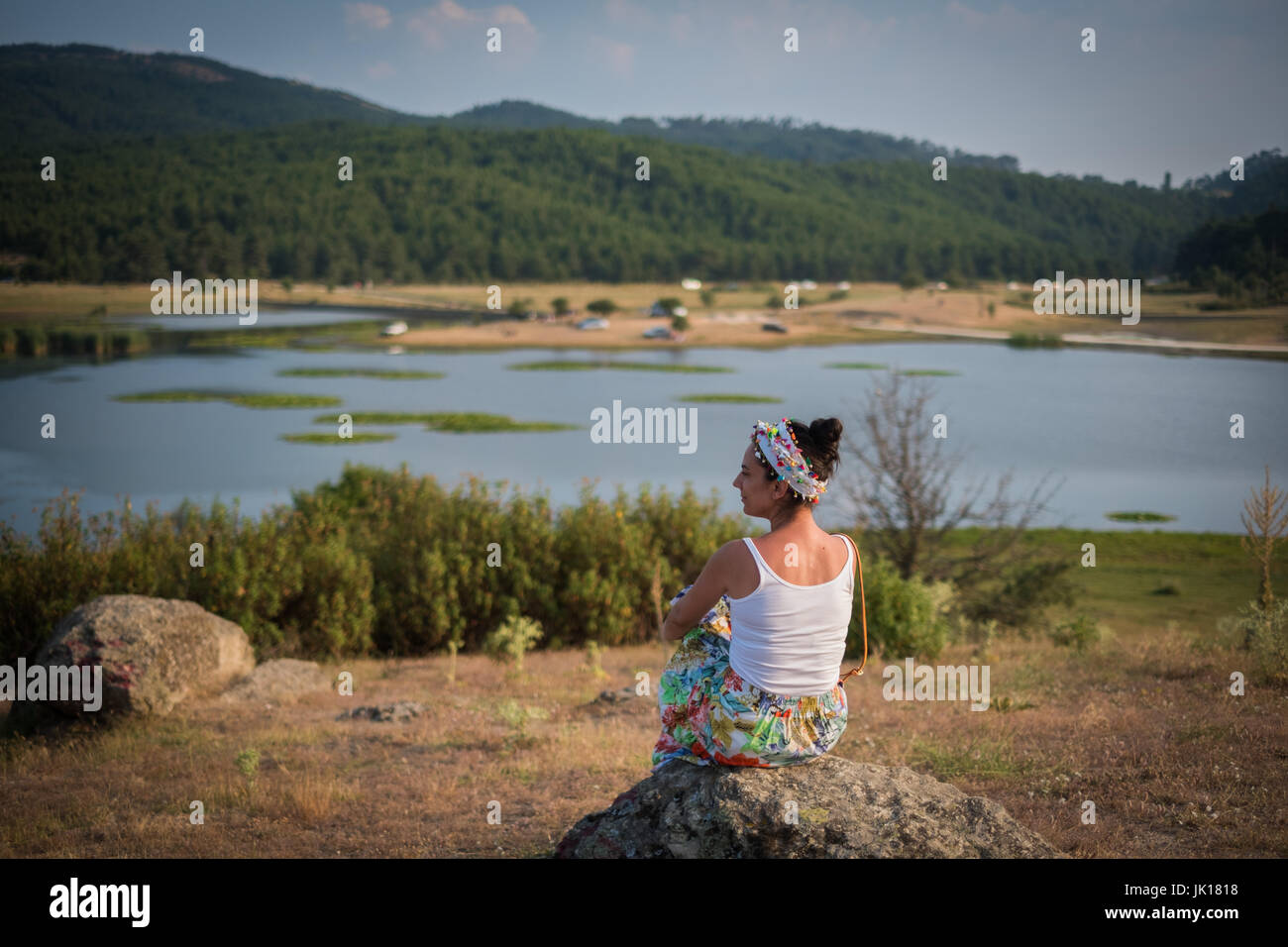 Femme assise sur le rocher Banque D'Images