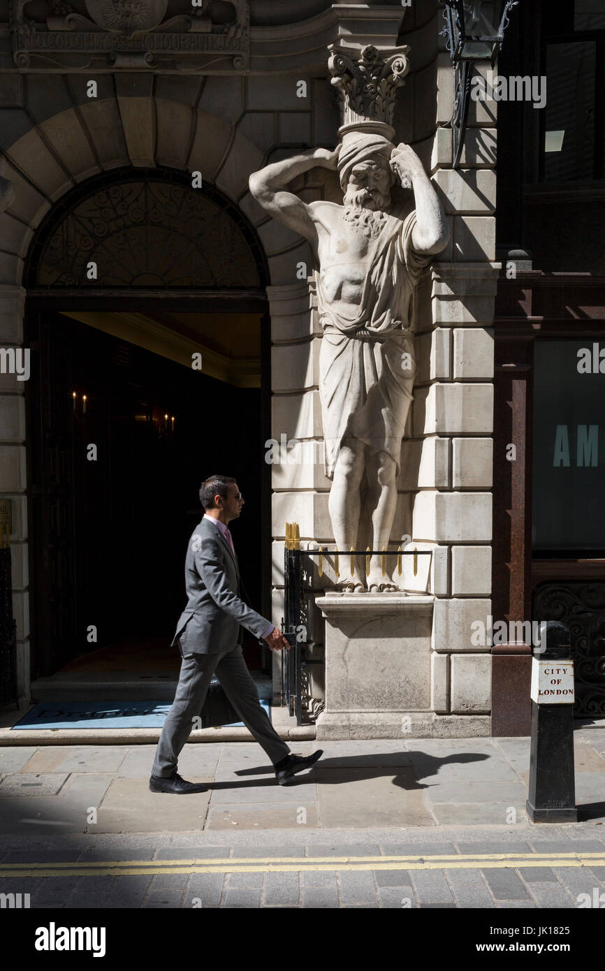 Un homme passe devant un Atlantes figure par le sculpteur H.A. Pegram (1896) à l'entrée de Drapers' Hall livery company à Throgmorton Street, le 17 juillet 2017, dans la ville de Londres, en Angleterre. Les tabliers' Company est une société livrée dans la ville de Londres dont les racines remontent au 13ème siècle, lorsque comme son nom l'indique, il a été impliqué dans le commerce de draperie. Bien qu'il n'est plus impliquée dans le commerce, l'entreprise a évolué l'acquisition d'une nouvelle pertinence. Son rôle principal aujourd'hui est d'être le fiduciaire du fonds de bienfaisance qui ont été laissées dans son soin au cours des siècles. La société a également Banque D'Images