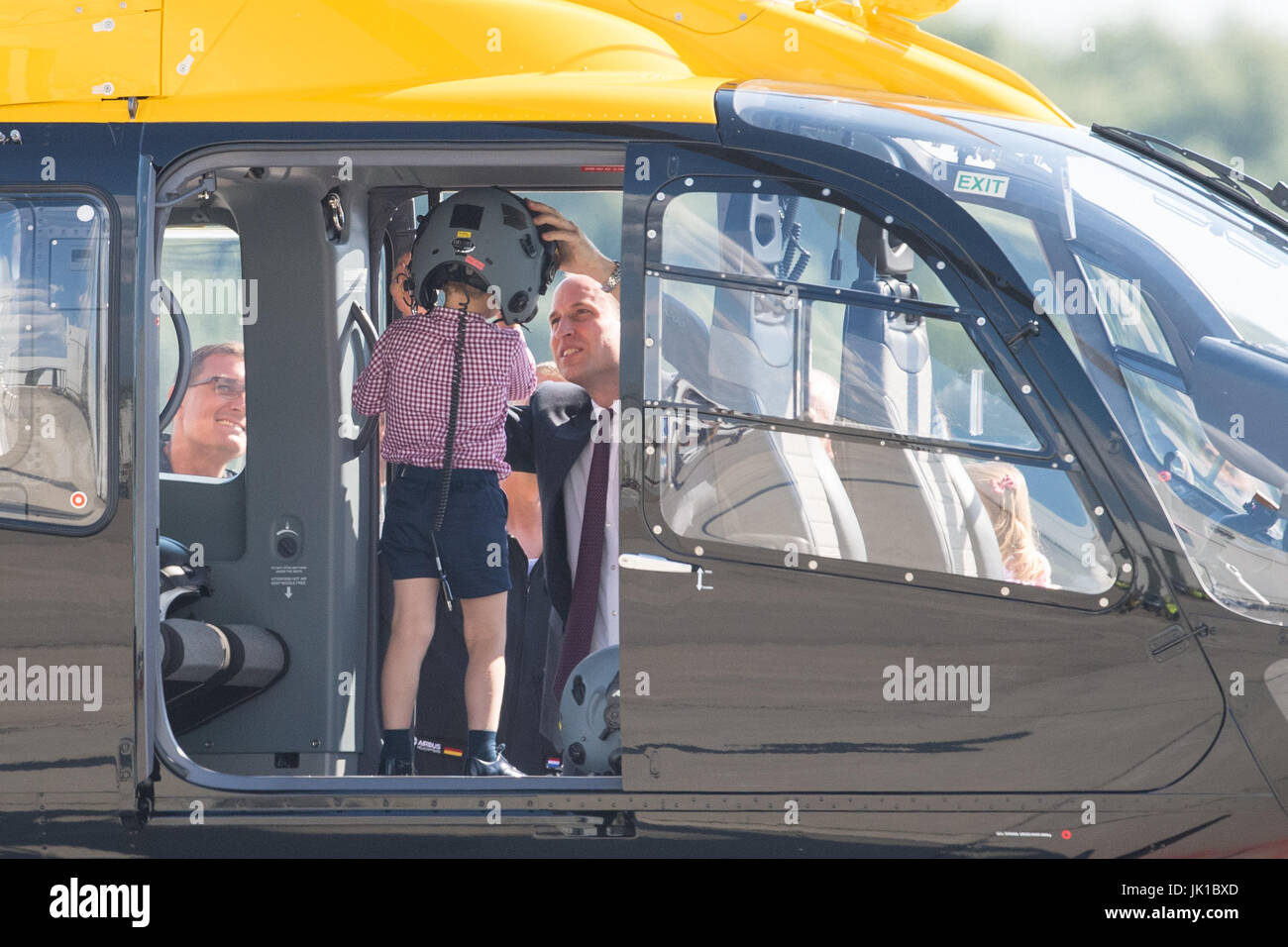 Prince George est dans un hélicoptère de sauvetage comme son père le duc de Cambridge met un casque sur sa tête, au cours d'une visite d'Airbus à Hambourg, en Allemagne avec la duchesse de Cambridge et sa sœur La Princesse Charlotte. Banque D'Images