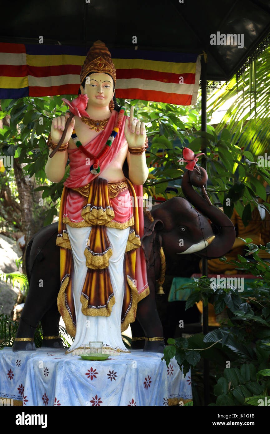 Galle Sri Lanka Sri-Vivekaramaya Rumassala Road Temple Statue de Dieu Sumana Saman tenant une fleur de lotus et Comité permanent par un Éléphant Banque D'Images