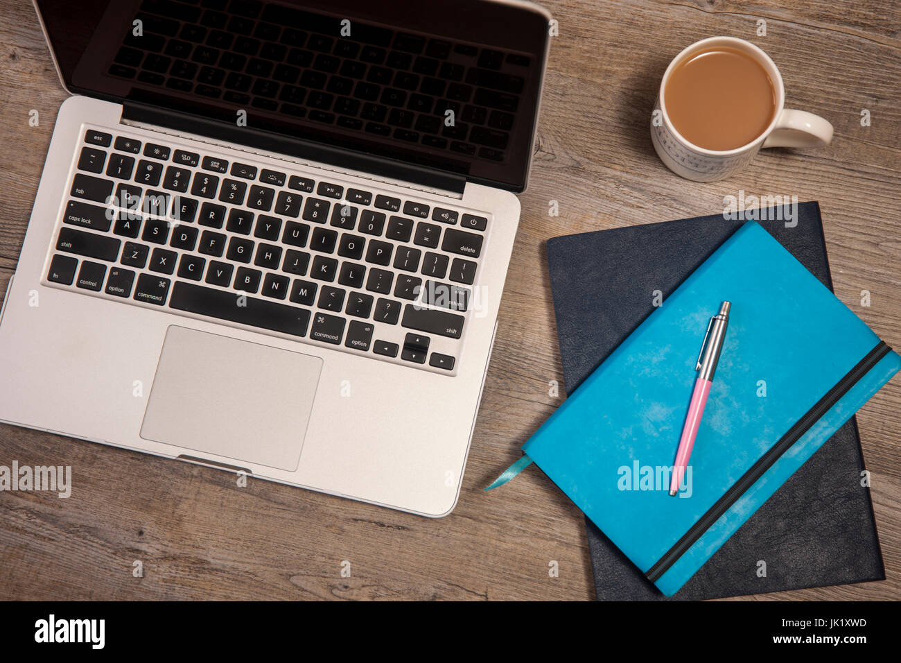 Ordinateur portable, ordinateur portable, agenda et tasse de thé sur une table de bois d'en haut. Banque D'Images