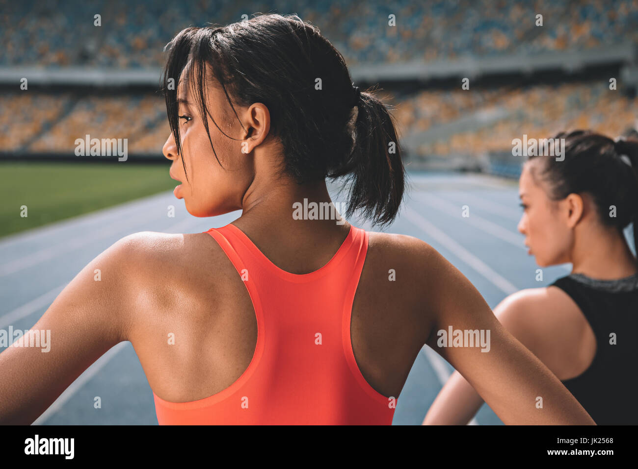 Les jeunes femmes sportives dans l'exercice de sport sur une piste de course stadium Banque D'Images