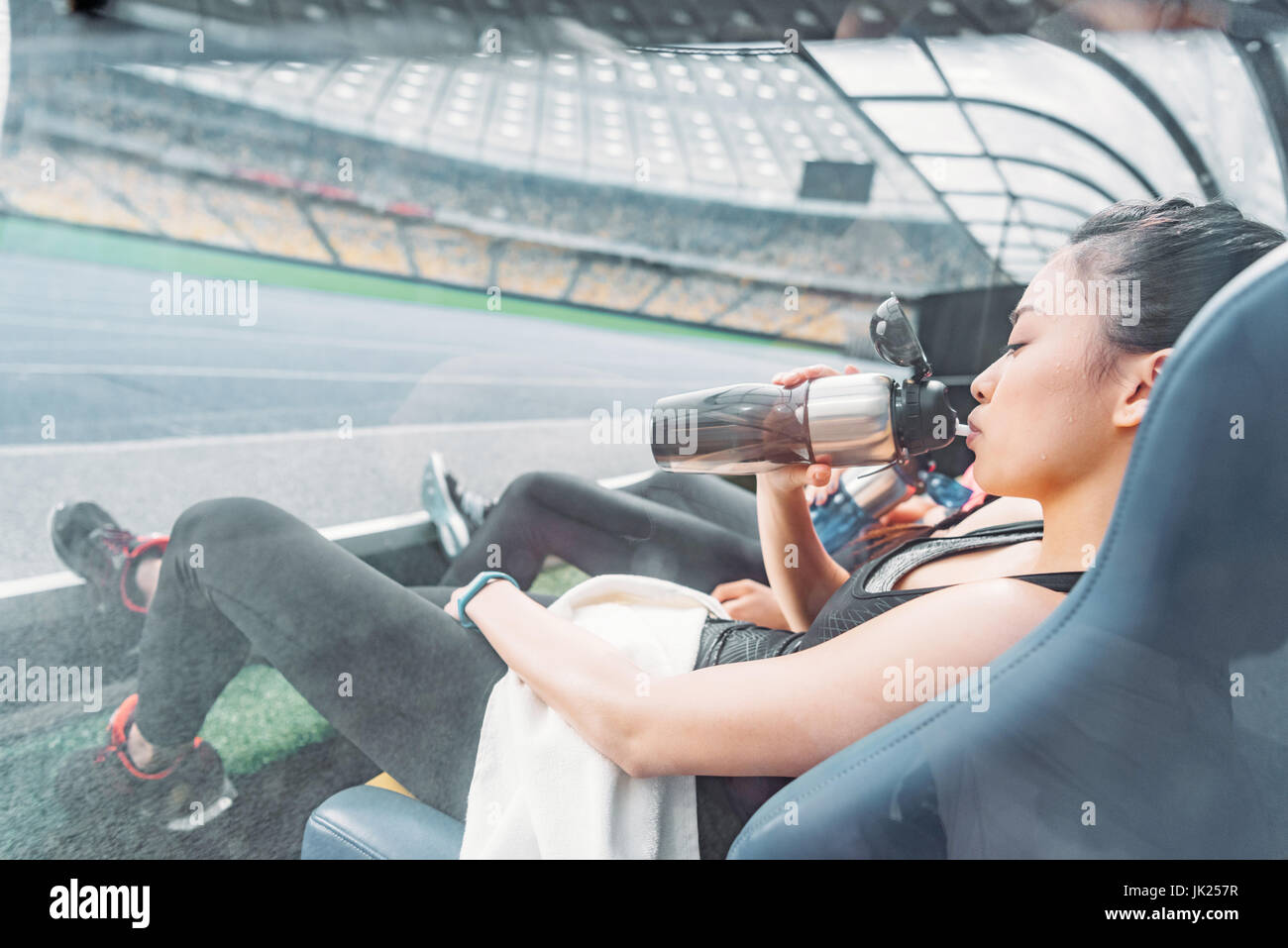 Les jeunes femmes remise en forme fatigué dans les vêtements de sport au repos dans les sièges du stade Banque D'Images