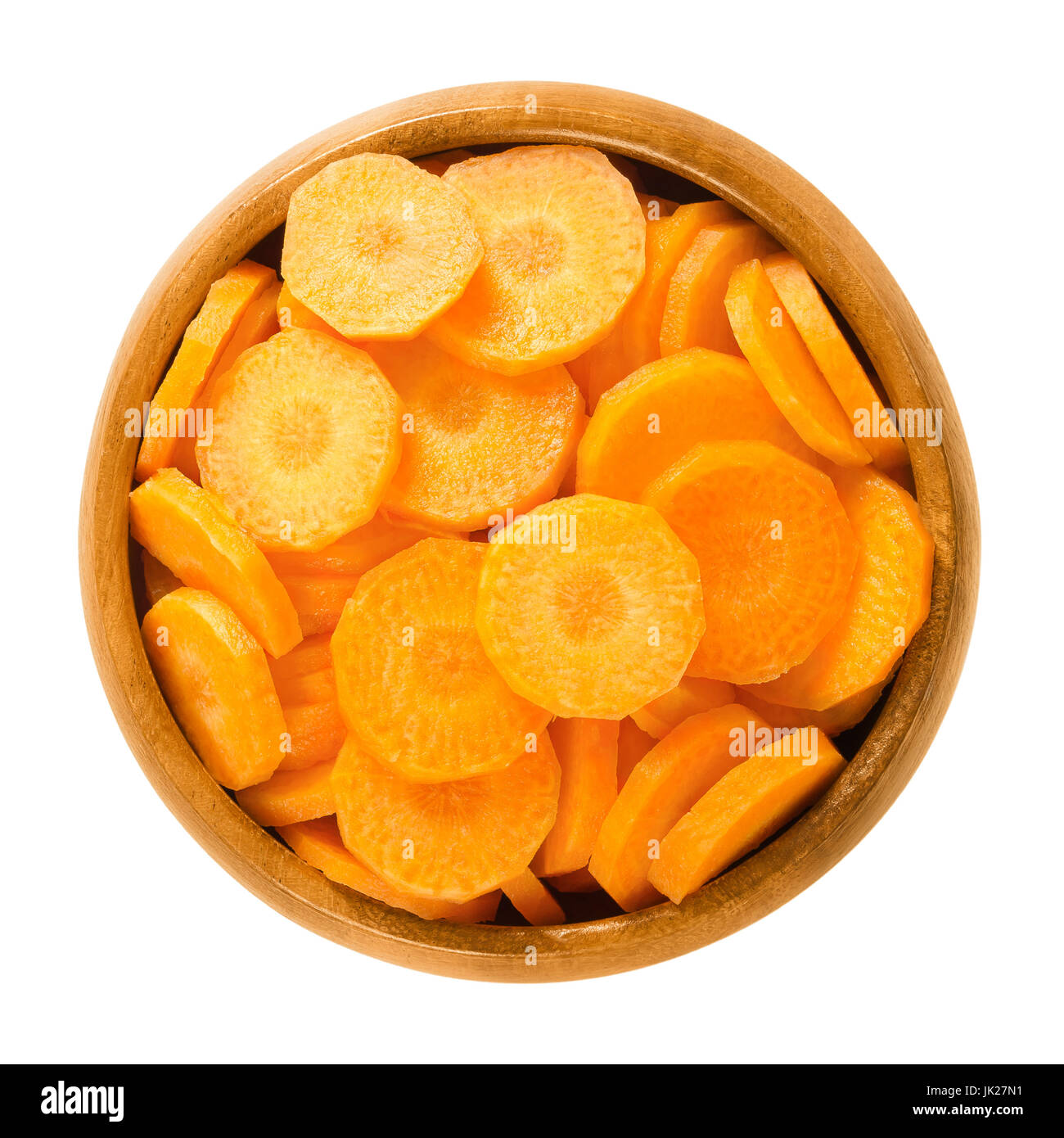 Les tranches de carottes dans un bol en bois. Des frais d'éclats de Daucus carota, un légume-racine avec la couleur orange. Racine pivotante comestible morceaux. Photo. Banque D'Images