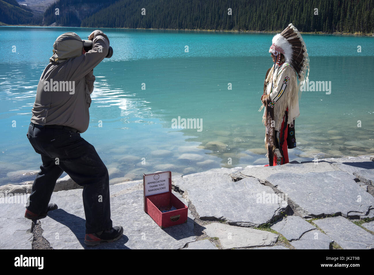 Première Nation Indian posant pour une photo au bord du lac. Banque D'Images